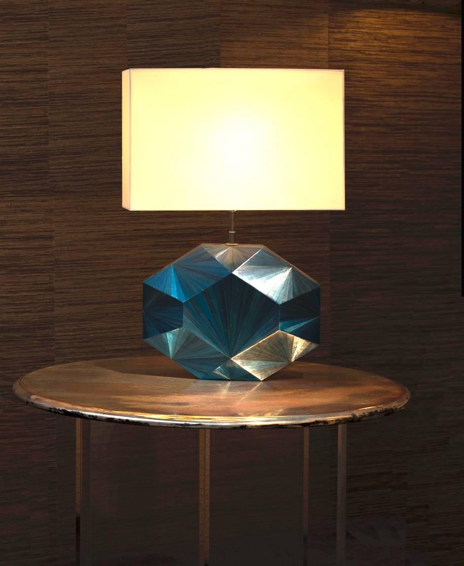 Ancient straw marquetry technique takes modern flair in our “Eloane” sapphire faceted table lamp. Features brass bulb holder and black twisted silk cord. Ivory silk lampshade sold separately, €200.
Straw color blue (color reference : BV) Can be
