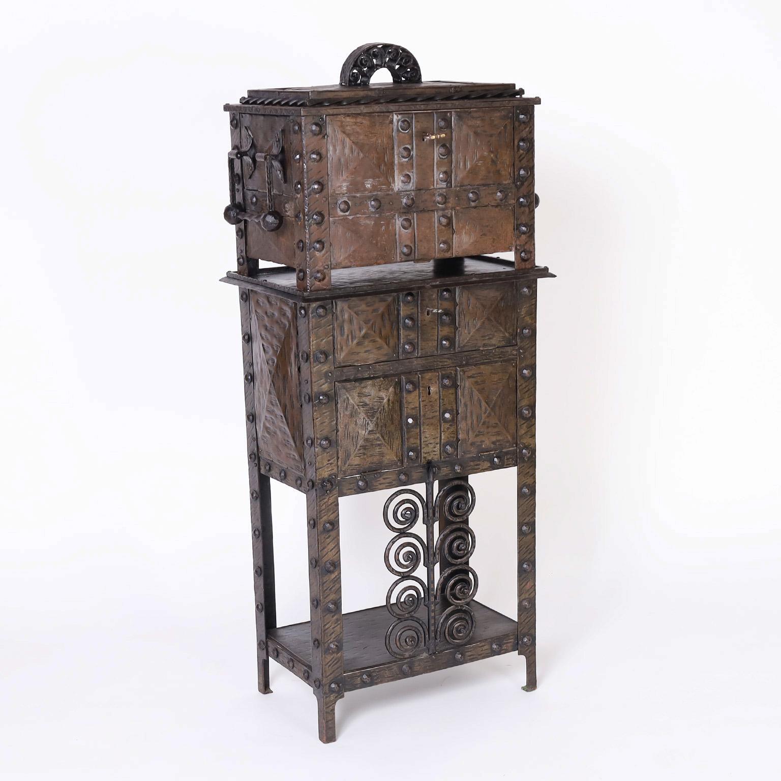 Rare and remarkable French two piece bar cabinet crafted in an eccentric composition of bronze and iron with hand hammered handles, rivets, spiraling designs and lockable compartments.