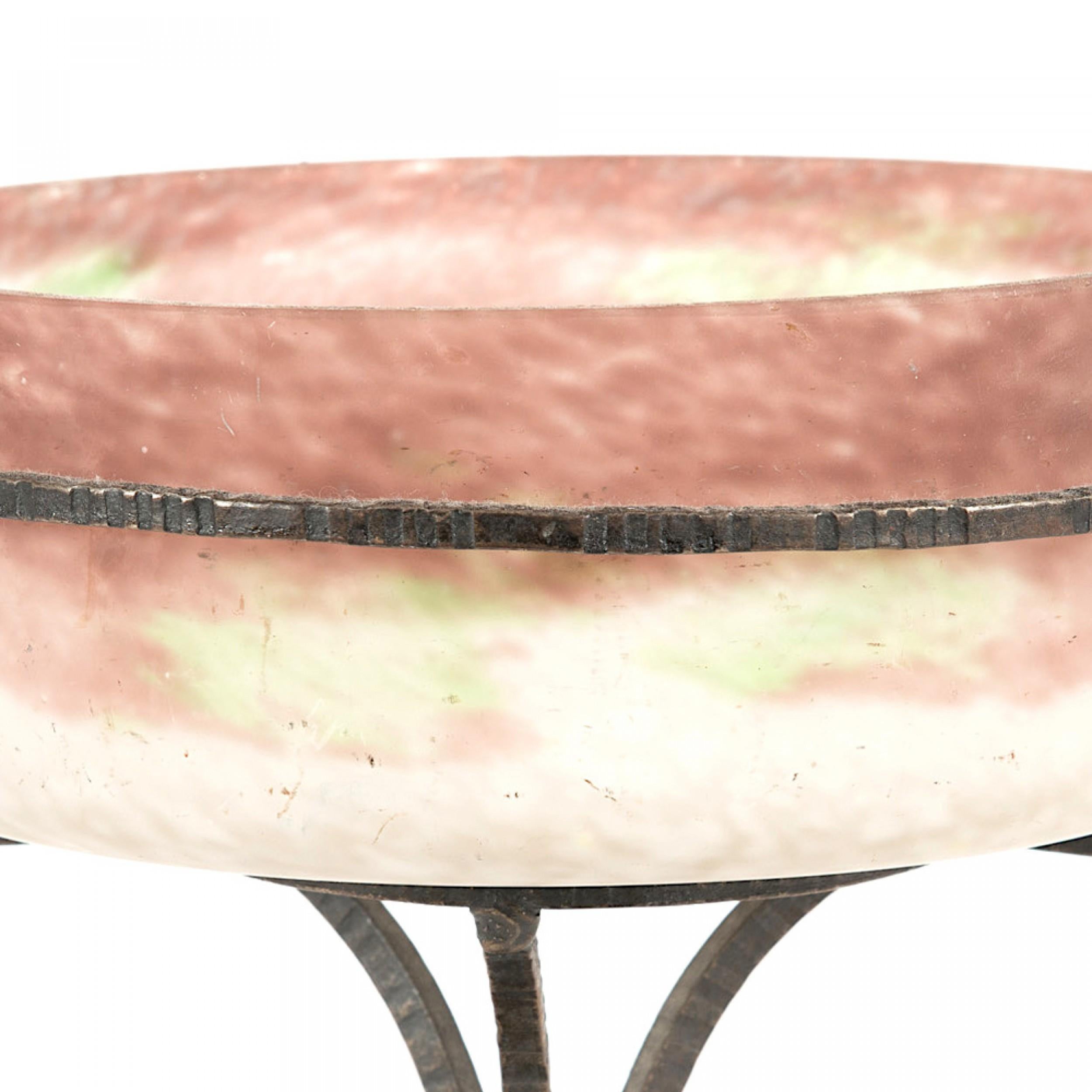 French Art Deco compote with a mauve, green, pink, and white frosted glass round bowl in a wrought iron stand with a triangular base and two scrolled handles (signed, DEGUE)