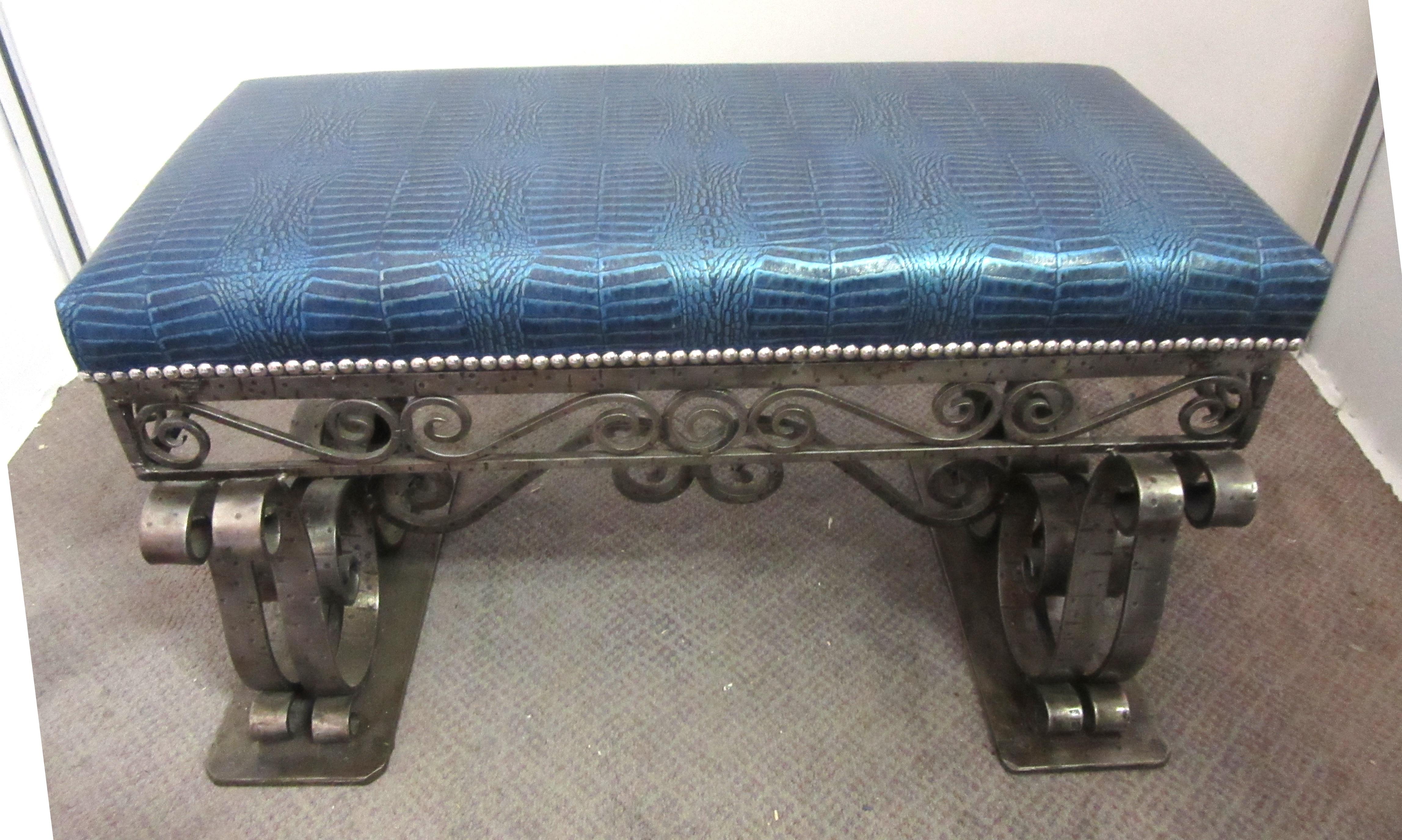 French Art Deco iron bench with elaborate scrolling ornament and heavy details. The bench seat was recently upholstered in a blue faux alligator leather with chrome nailheads.
In great vintage condition with age-appropriate wear and use.