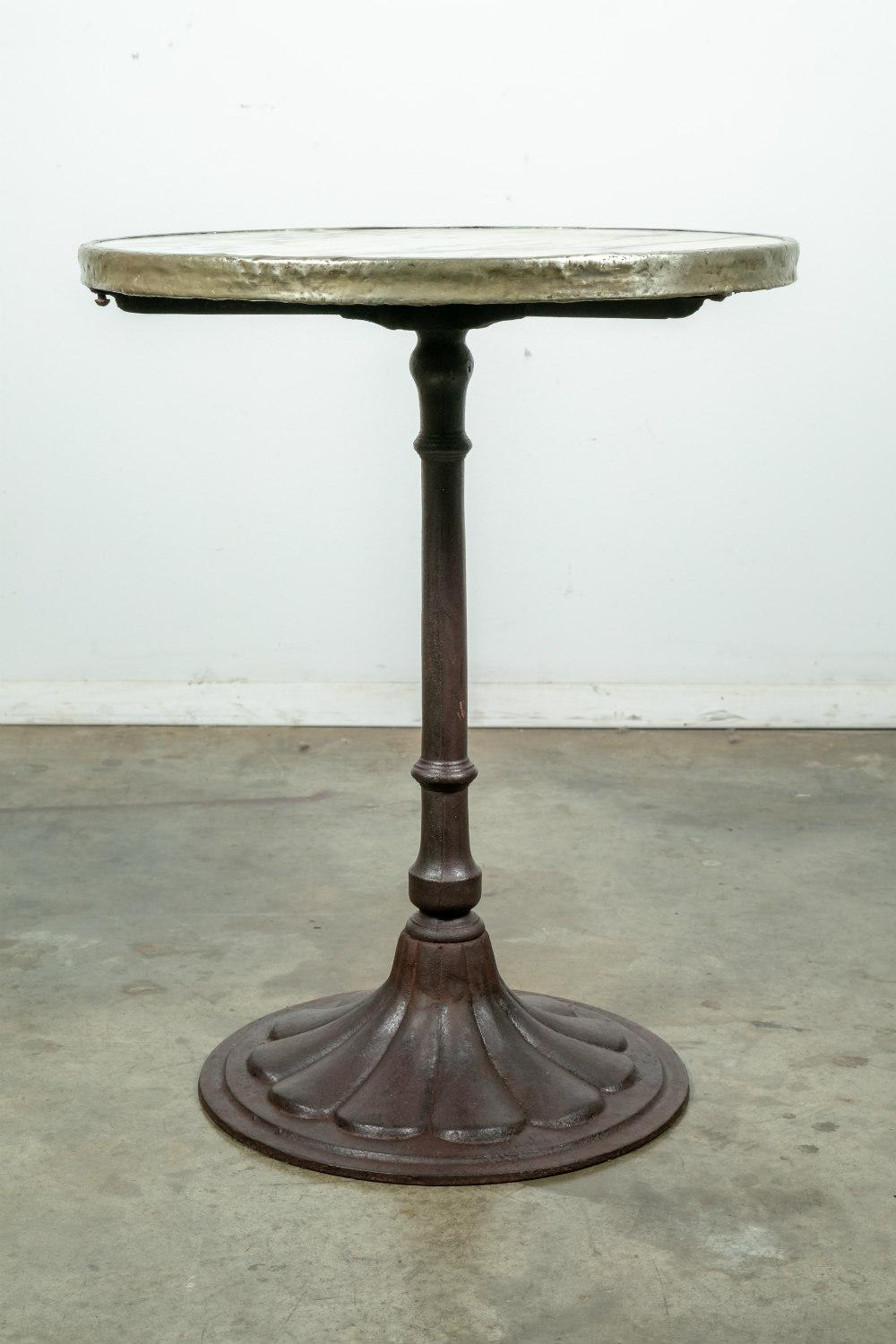 An early 20th century French cast iron Parisian Art Deco bistro table, having the original Carrara marble top with brass surround. Raised on a rare tulip base with a lovely aged patina. This table would be a wonderful garden or patio table, as well