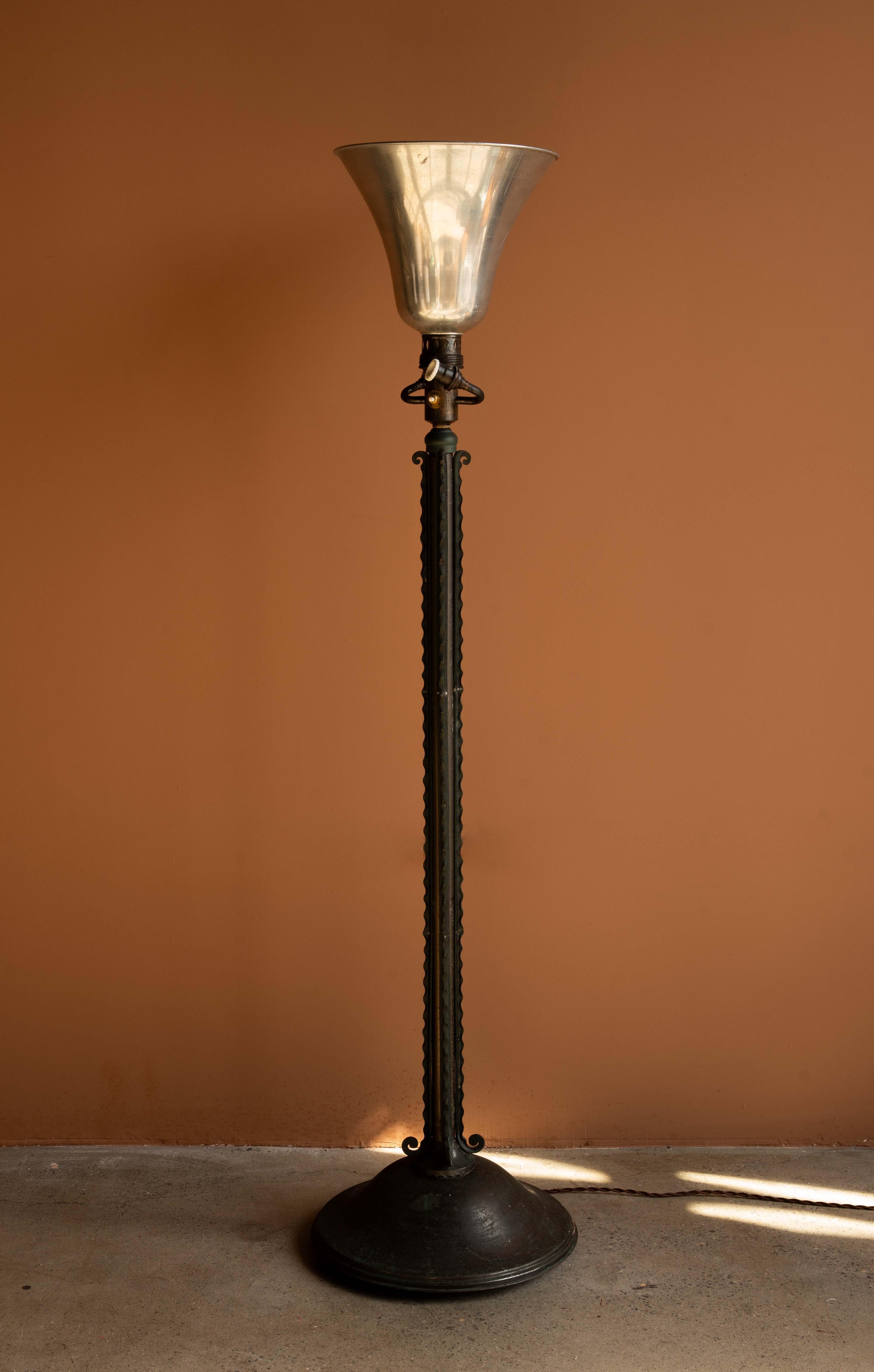 Un lampadaire vintage Art Deco en fer forgé par les Ateliers Etlin de Paris. Cette pièce est décorée de détails en fer forgé cannelé et d'un socle en forme de cloche mesurant 15 pouces de diamètre. La tige est réglable, avec une plage de hauteur de