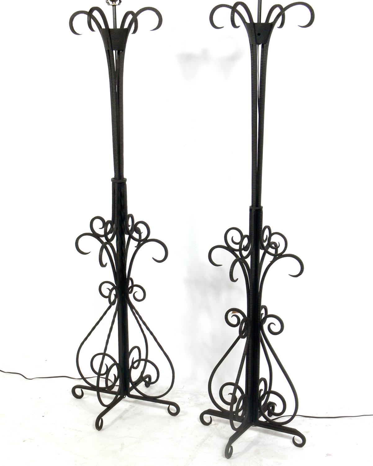 French Art Deco iron floor lamps, France, circa 1930s. As they are each unique, they are not quite an exact pair. They have slight differences in construction and size, only noticed when right next to each other. The floor lamp on the left measures