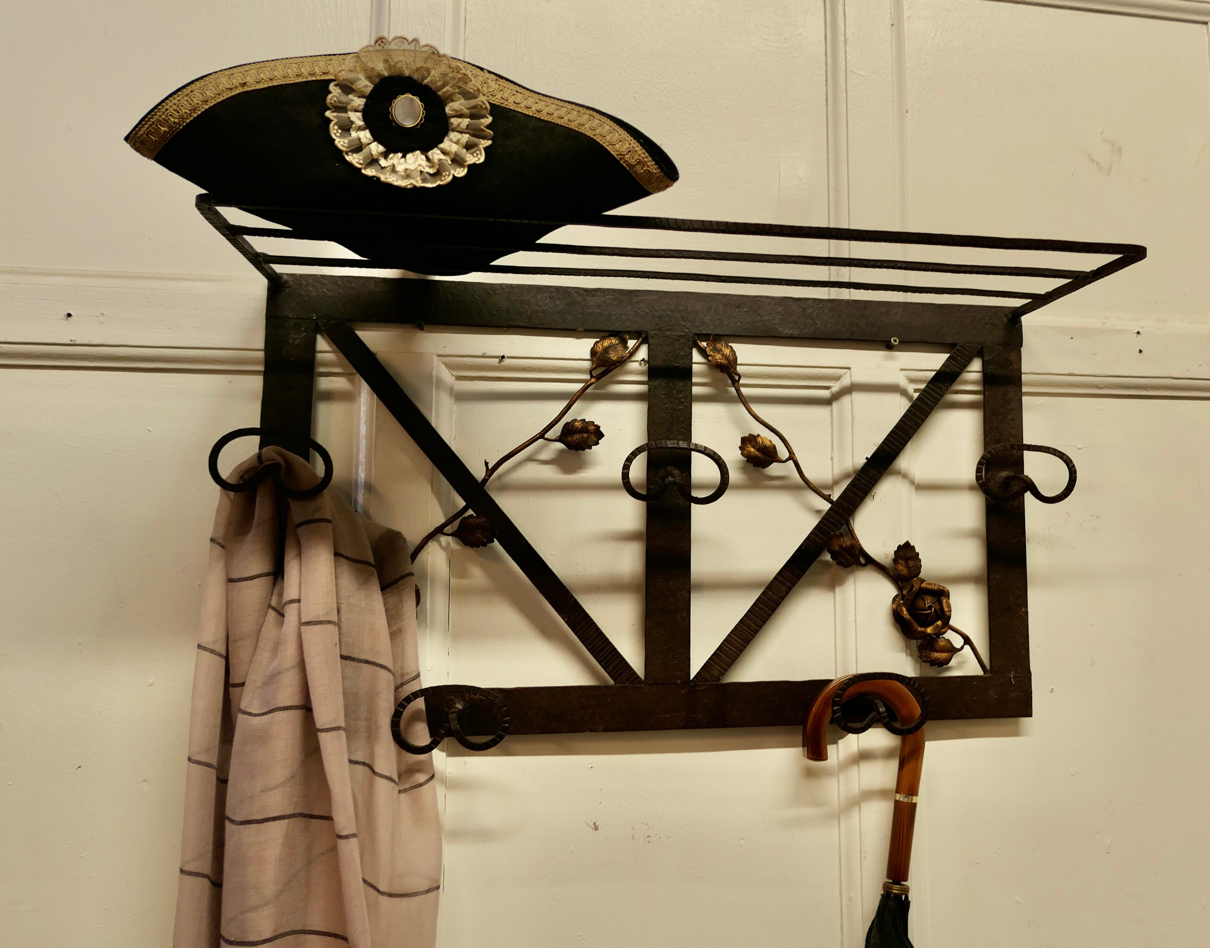 French Art Deco iron hat and coat rack with shelf decorated with roses.

This Art Deco period piece coat rack includes a shelf over the top and 3 large coat hangers ands 2 double hooks below. The Iron frame os decorated with roses picked out with
