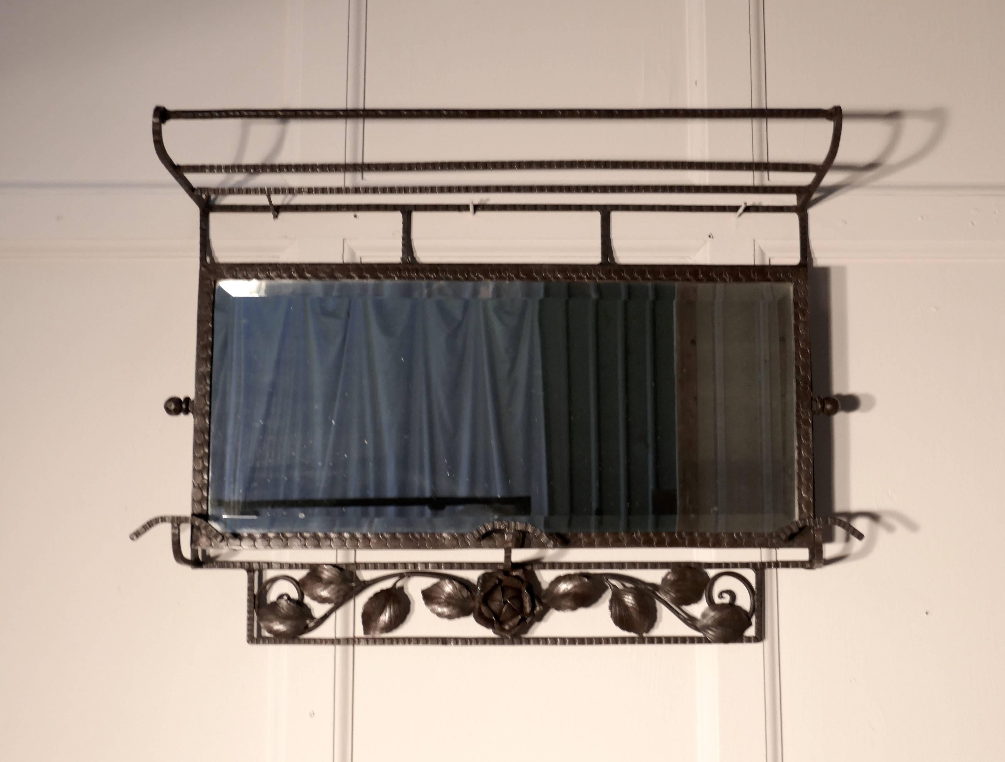 French Art Deco iron hat and coat shelf brutalist mirror, Pullman style.


 This Art Deco period piece the rack includes its original bevelled swivel mirror that adjusts to the proper angle for viewing, it has three hooks and an upper shelf