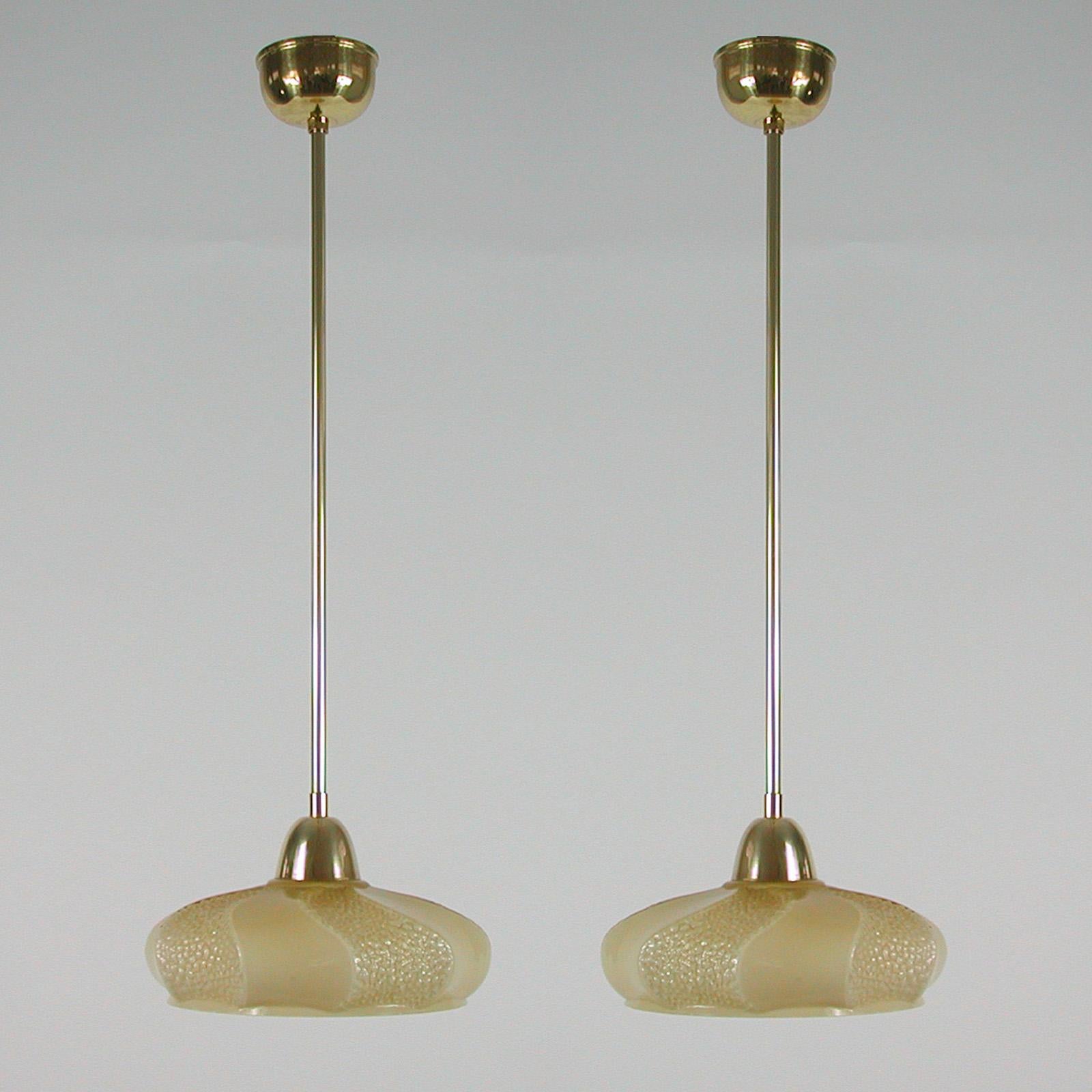 These elegant pendants were designed and manufactured in France in the 1930s to 1940s. The lights feature an ivory / cream colored opaline lamp shade and brass hardware.

Good vintage condition with one original E14 socket. 

The lamps have been