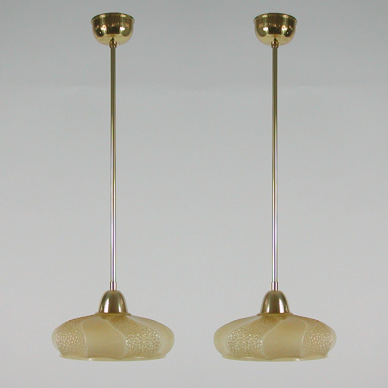 These elegant pendants were designed and manufactured in France in the 1930s to 1940s. The lights feature an ivory / cream colored opaline lamp shade and brass hardware.

Good vintage condition with one original E14 socket. 

The lamps have been
