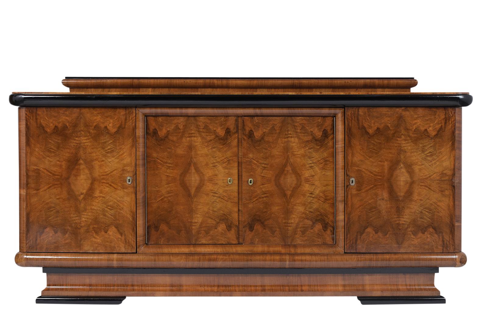 This French Art Deco buffet circa 1940s has been professionally restored, is made out of walnut wood and finished in a light walnut color with ebonized molding accents details with lacquer finished. This Sideboard comes with four doors that are