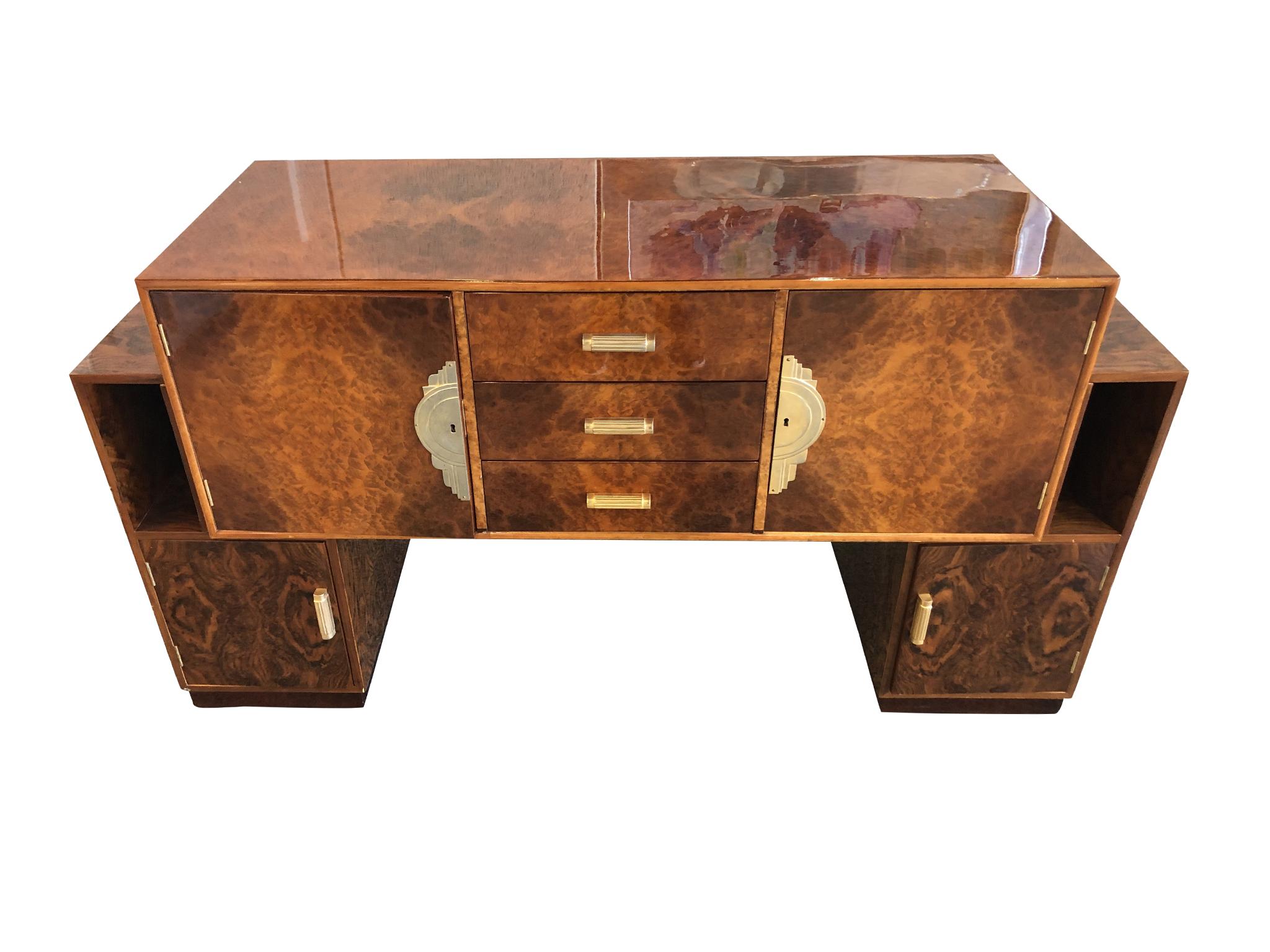 An exceptional French Art Deco sideboard cabinet crafted from burl with a lacquered finish and walnut veneer, circa 1930s. The wood has a warm honey-brown tone, while brass pulls, hinges, and trims add to the golden sheen. Its alluring grain pattern