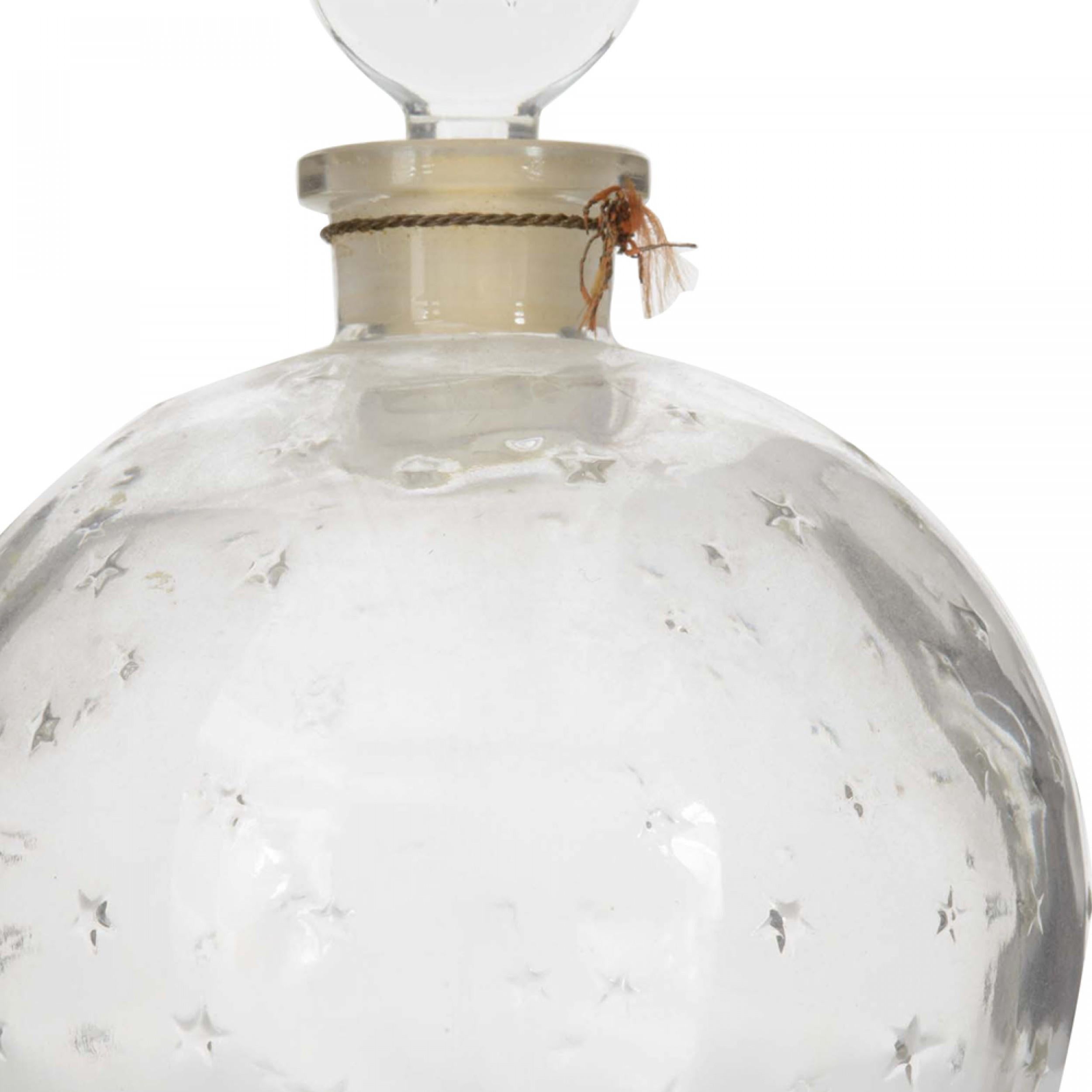 Frasco de perfume francés Art Déco de cristal en forma de bola con un diseño de estrellas en relieve y un tapón plano de cristal redondo grabado con la letra W  (firmado LALIQUE para Worth)