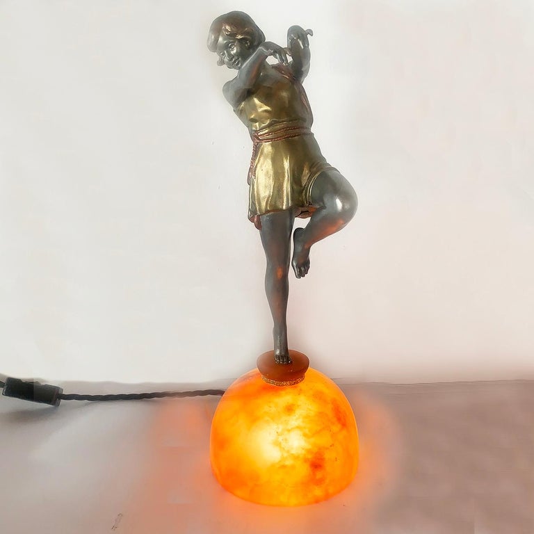 Art Deco French dancer lamp by Carlier. Dancer is mounted on top of orange toned marble, hollow half Dome that is illuminated. Bellow the finely detailed feet, is a small pedestal of the same marble, but separated with a detailed, engraved bronze