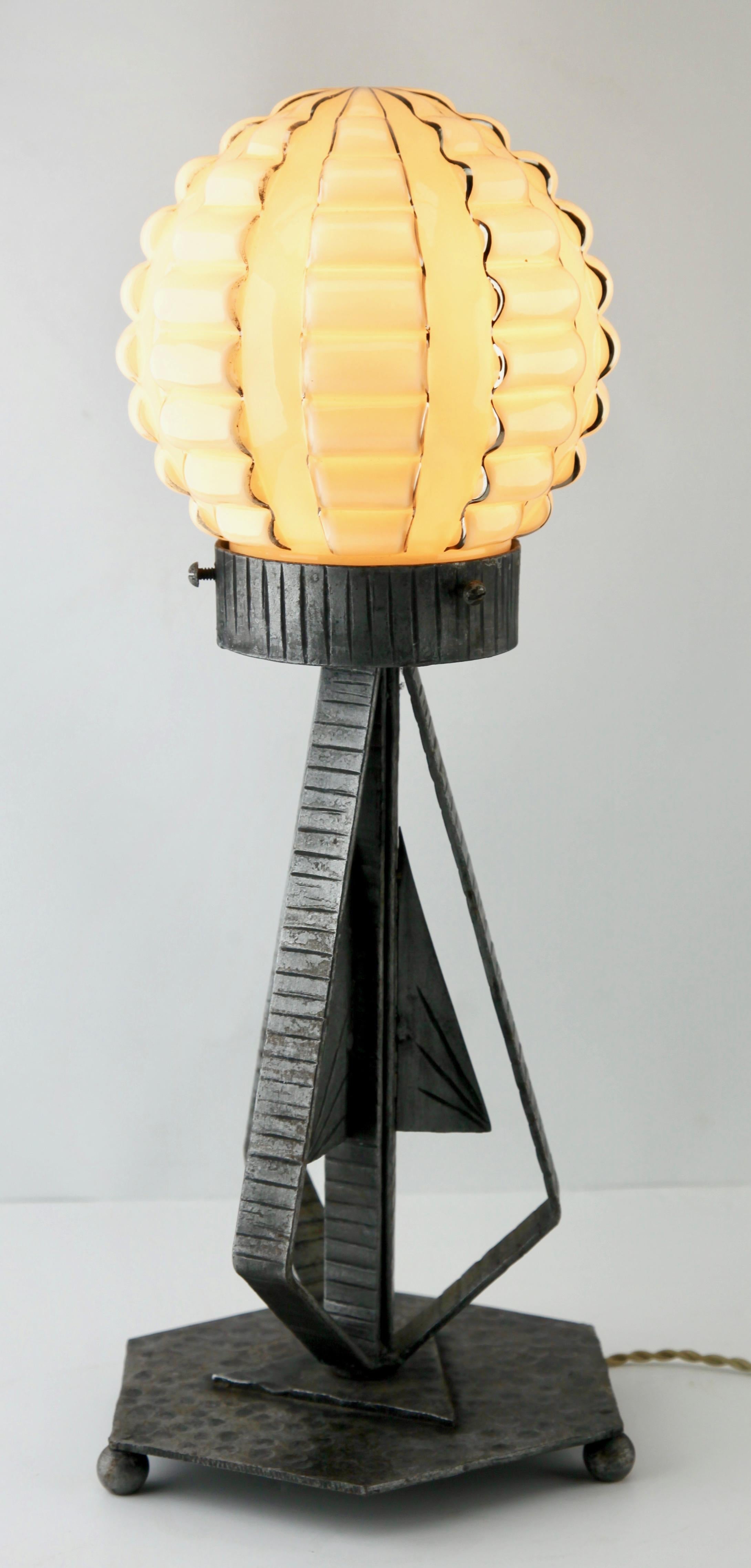 A wonderful French Art Deco lamp. The stands are handmade in wrought iron with black finish patina and hammered with a pattern. The metalwork is of excellent quality.
Crowned with bright shades in opaline glass with golden highlights.

In