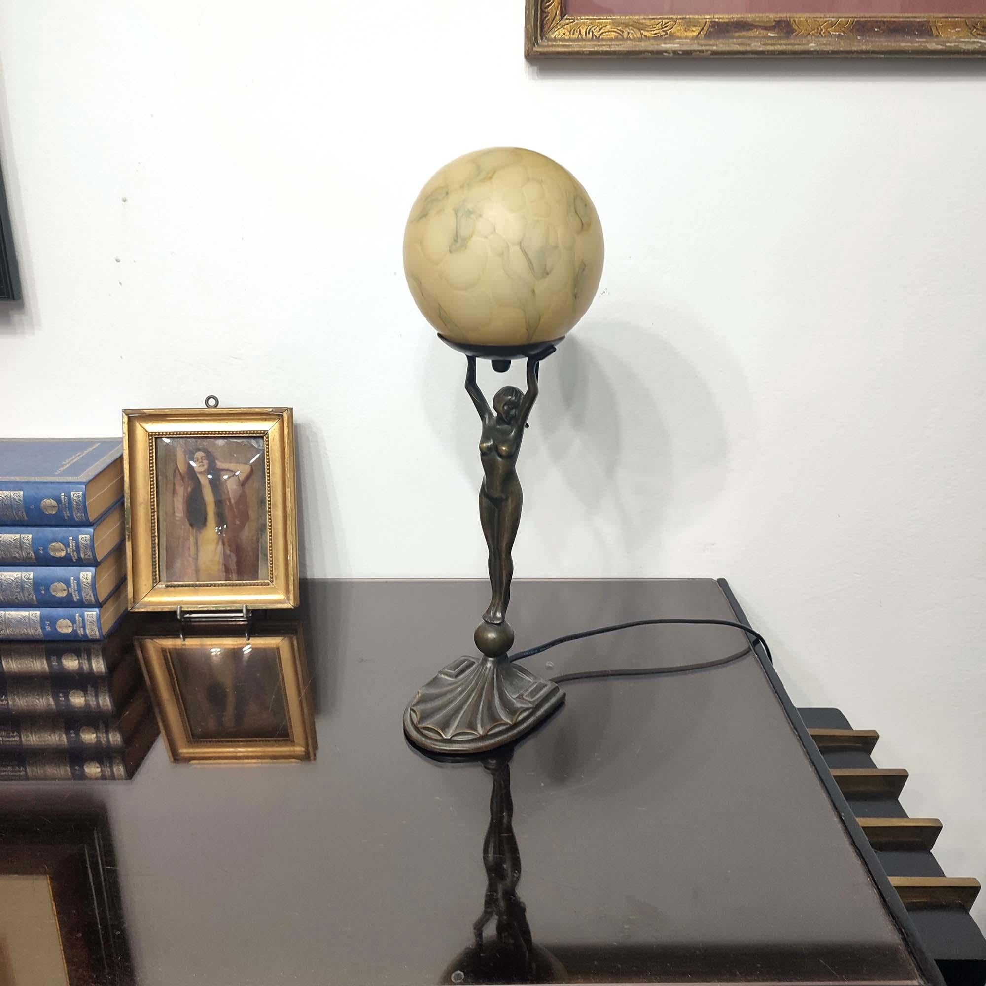 An Art Deco bronze figure lady table lamp, circa 1930, holding aloft a marbled glass globe. This is a particularly stylish example of this type of table lamp. Very good original condition, fully rewired.
Height 40cm.