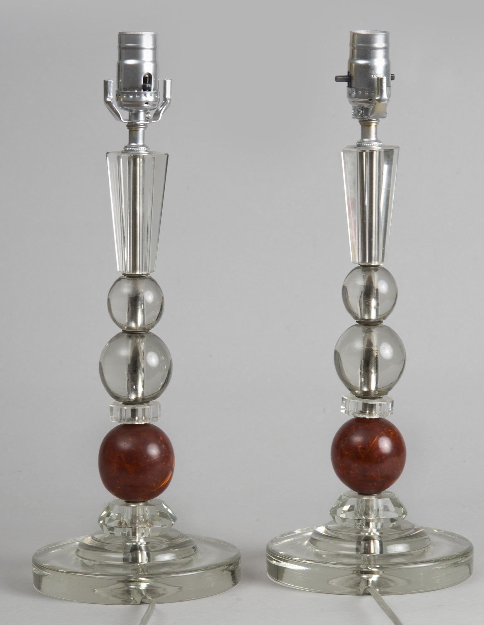 French pair of Art Deco lamps, circa 1920. Stacked above the round glass base are three spherical glass orb shapes, the bottom one being a dark amber color, atop those is a three and one-half inch tapered hexagonal shape.