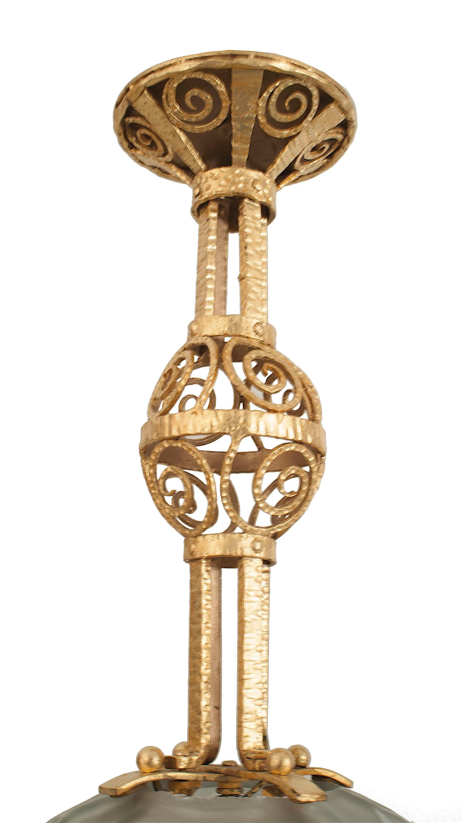 Französische Art-Déco-Laterne aus handgehämmertem Eisen und Blattgold mit geometrischem Wirbelmuster, das eine facettierte Milchglas-Kugel (SABINO) trägt (GENET MICHON).
 