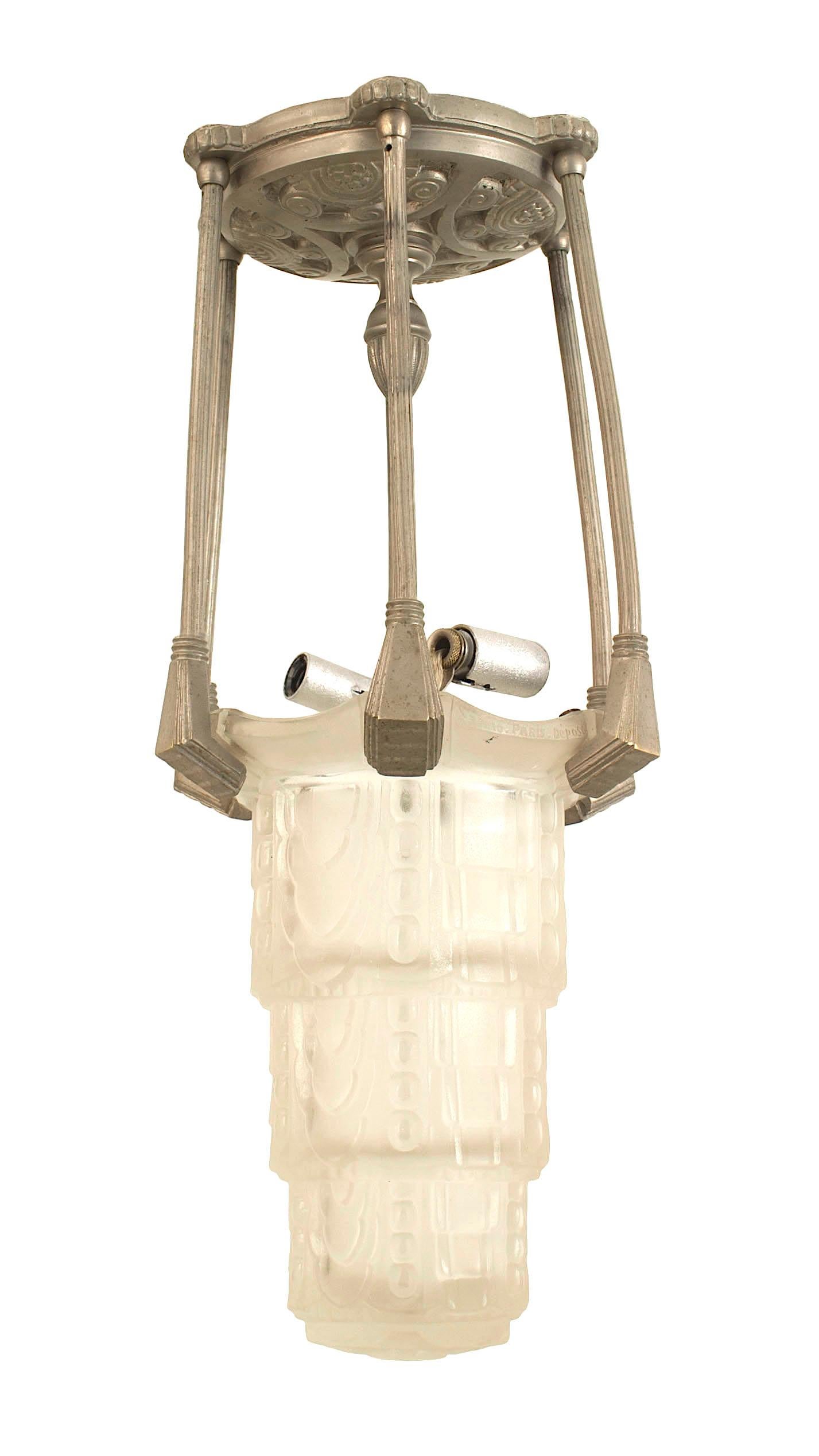 Kleine französische Laterne im Art déco-Stil (um 1925) mit einem 6-seitigen Schirm aus mattiertem, dreistufigem Pressglas, der an einem versilberten Metallrahmen unter einem großen runden Baldachin aufgehängt ist (SABINO).
