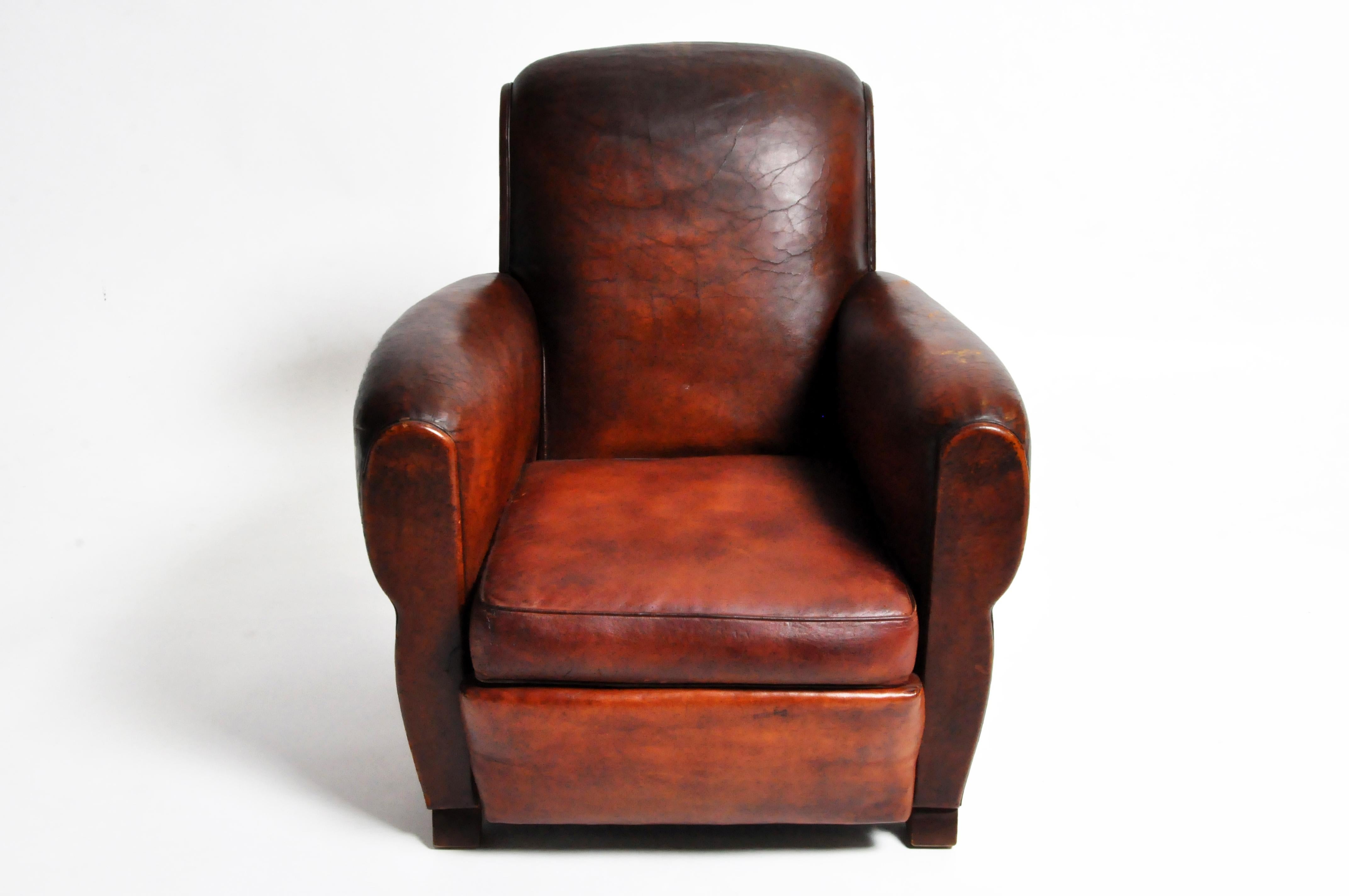This Classic French Art Deco armchair is made from leather and dates to the 1940's. The shape of the chair is elegant, with simple and curvaceous rolled arms and back that are not overly bulbous (as many French Deco chairs appear). It exudes quiet