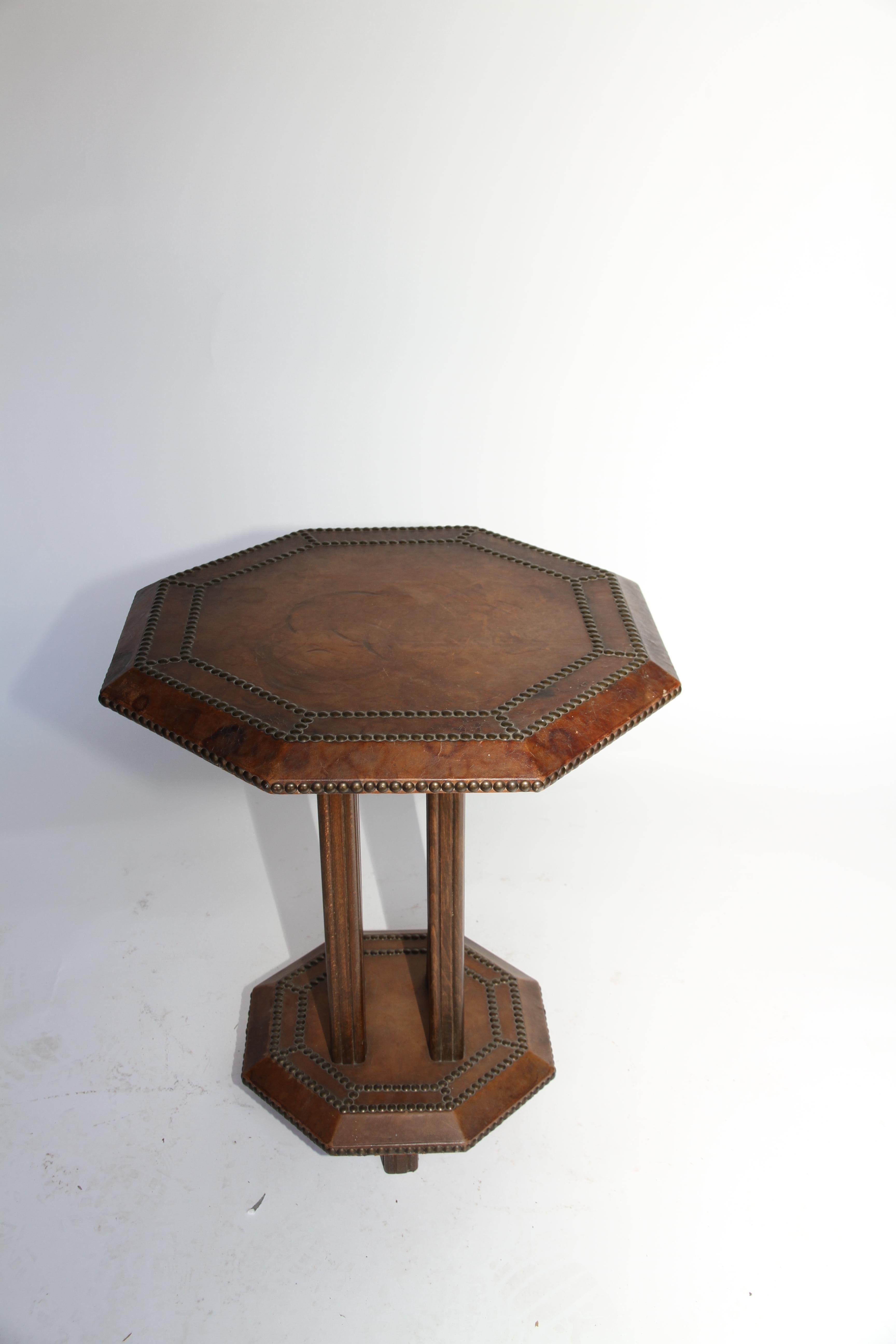 A handsome French Art Deco leather studded octagonal side table. The unique shape and brass stud detail add beauty and charm to the piece.