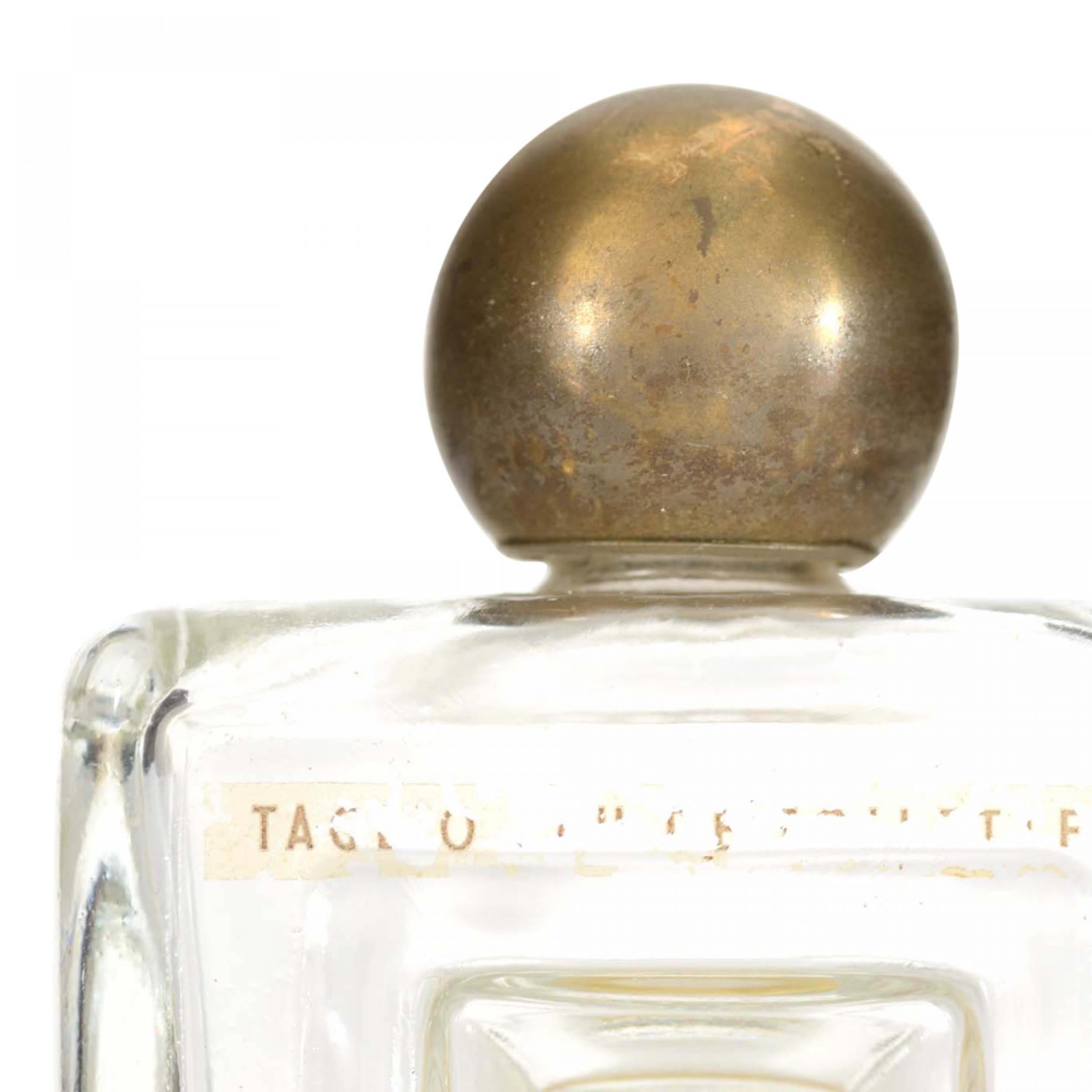 Bottiglia di profumo quadrata in vetro trasparente in stile Art Déco francese (di LUCIEN LELONG) con una rientranza quadrata al centro del corpo e un tappo a forma di palla in metallo dorato