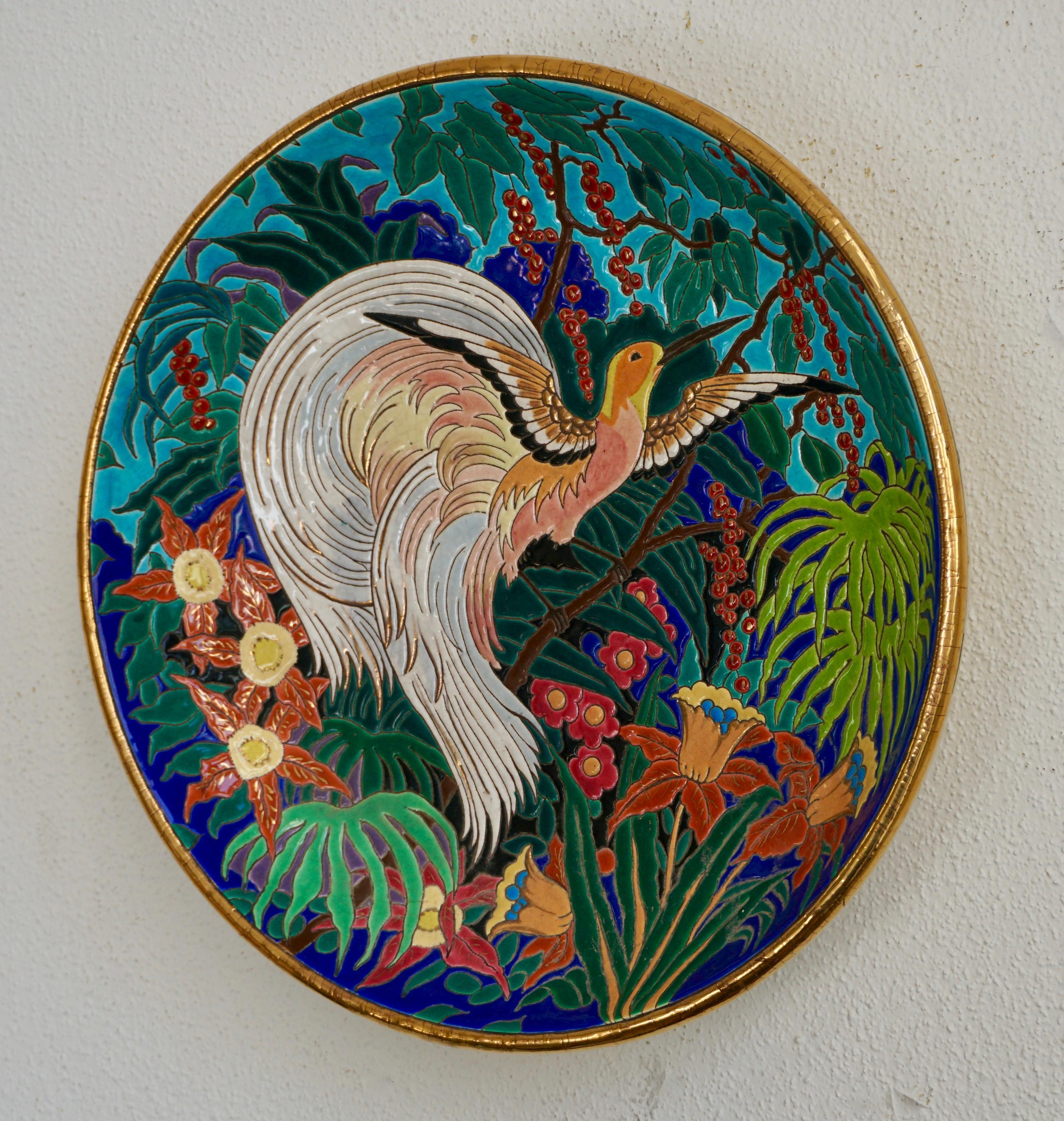 Wonderful large decorative French deep wall charger by Maurice Paul Chevallier for Fai¨ences de Longwy de Luneville. Decorated in a crackle glaze of vibrant colors and gilt and enameled with a bird surrounded by colorful foliage. Craquelle white