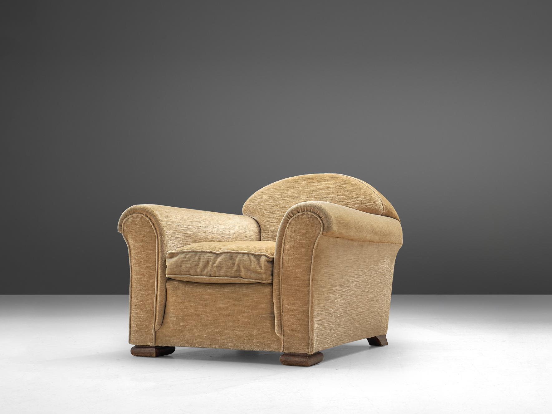 Lounge chair, fabric and oak, France, 1940s.

Wide and comfortable French club chair in a soft beige velours upholstery. A truly extraordinary lounge chair that features a very deep seat and rounded armrests that are in the style of Rene Drouet.