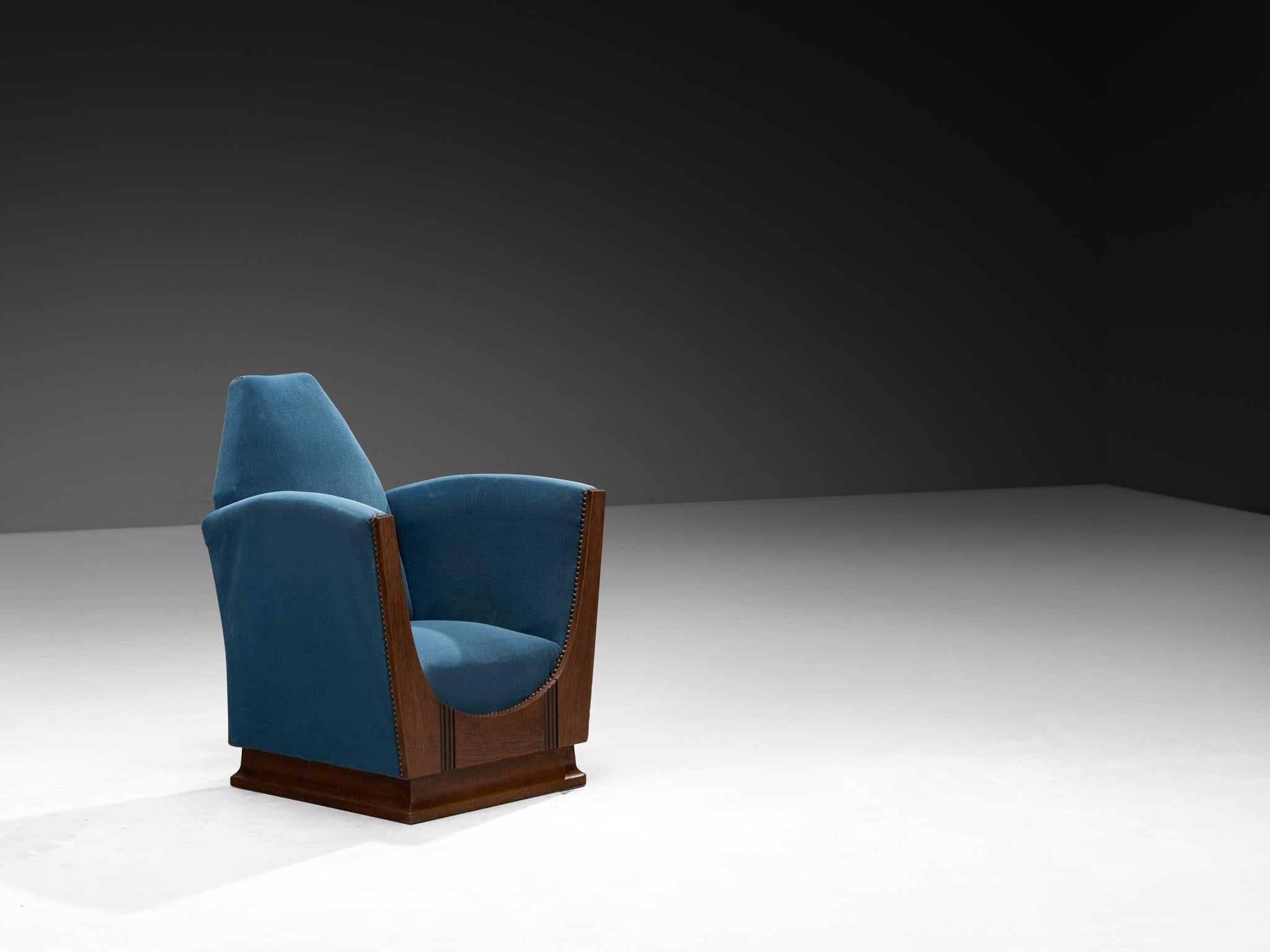 Lounge chair, velvet, oak, metal, France, 1920s

This 1920s French armchair is a striking example of the Art Deco movement, but it also carries a strong undercurrent of the Amsterdamse School, especially in its sculptural quality and heavy, grounded
