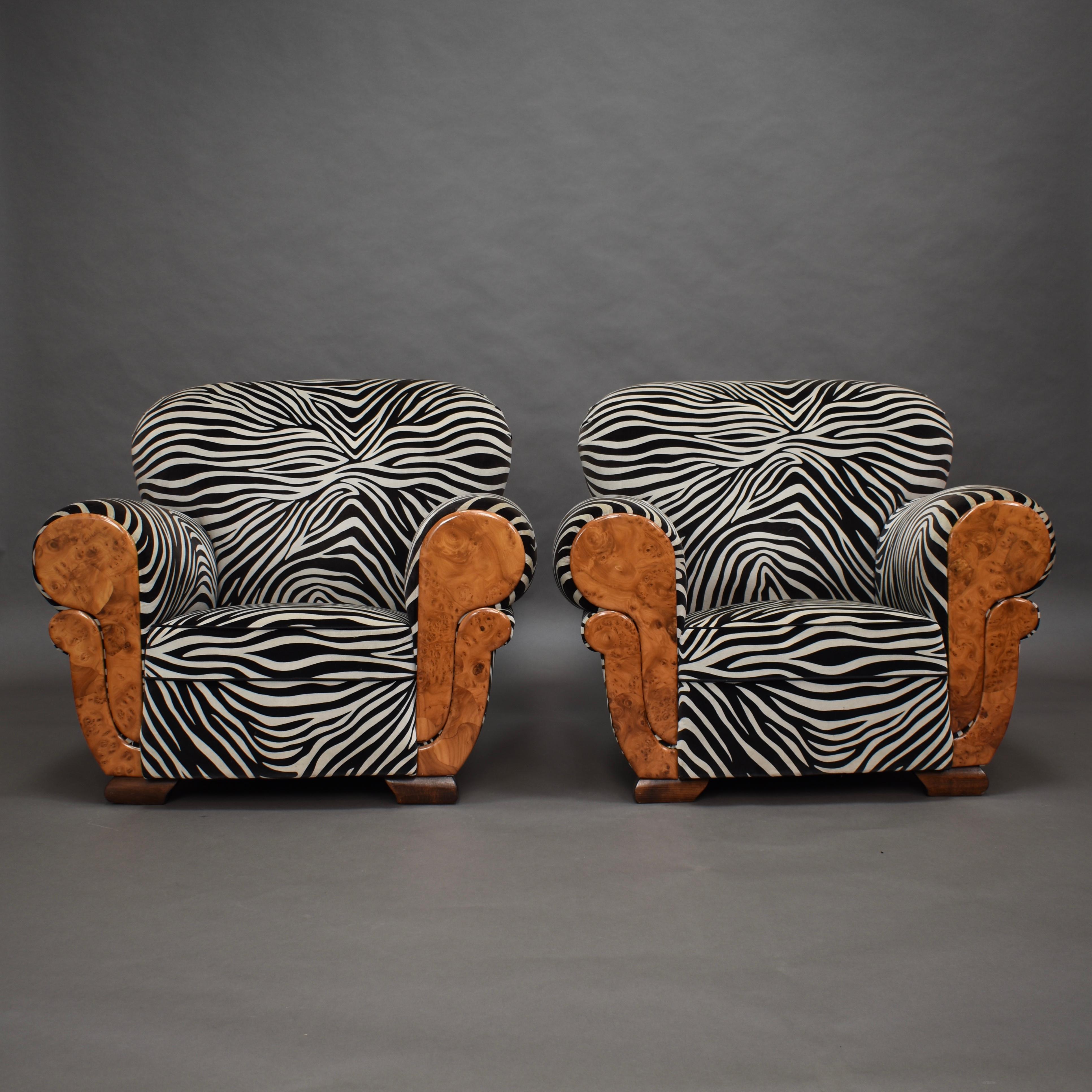 Oversized pair of French Art Deco lounge club chairs, circa 1920-1930. The front of the arms are covered in beautiful burl wood.
Very comfortable to sit in.

The fabric is a short haired velvet in Zebra print. 
The interior (foam / coil springs)