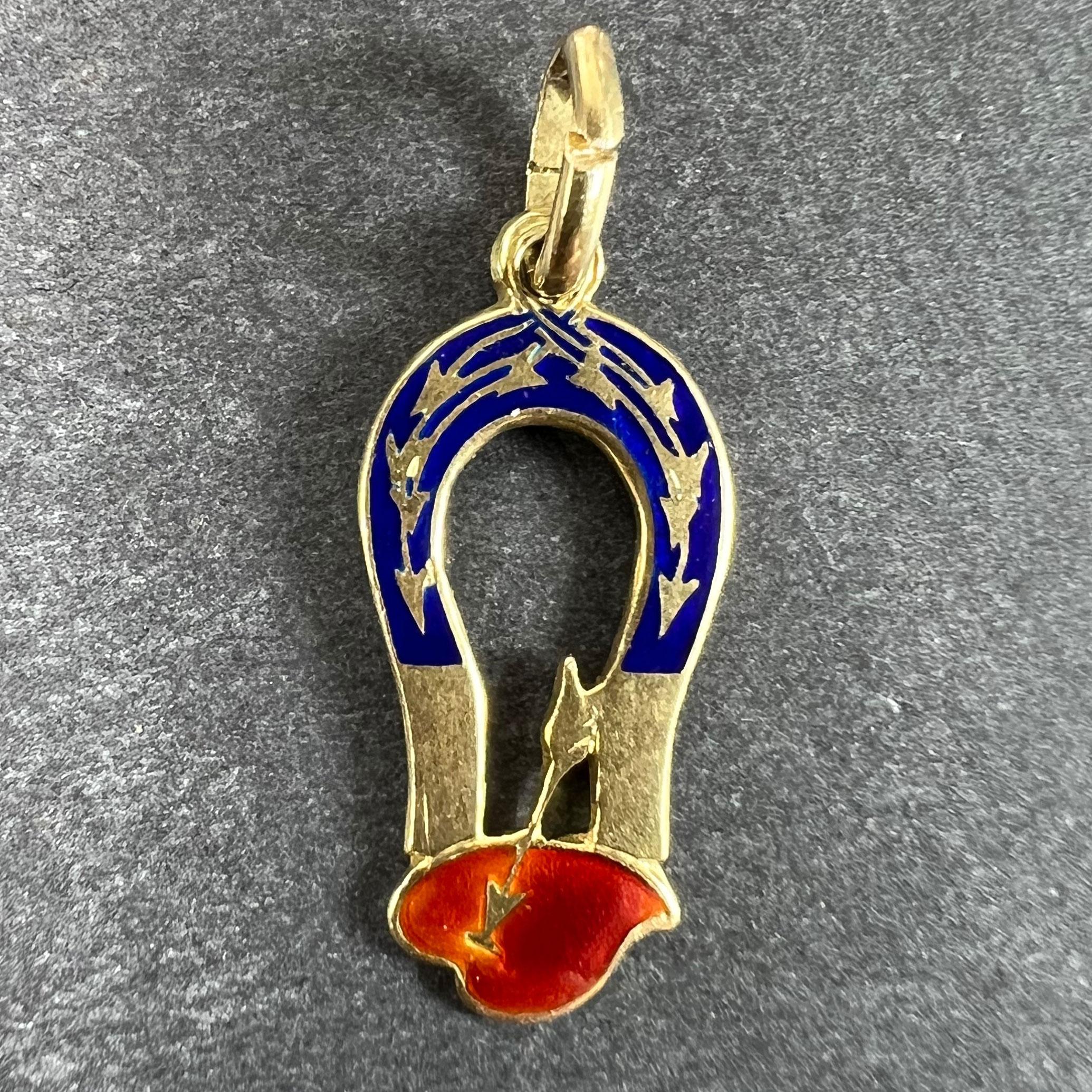 A French Art Deco 18 karat (18K) yellow gold charm pendant designed as a love magnet, set with red and blue enamel to show a red love heart struck with Cupid's arrow at the base of a magnet with blue enamel to the top with lines of force indicated