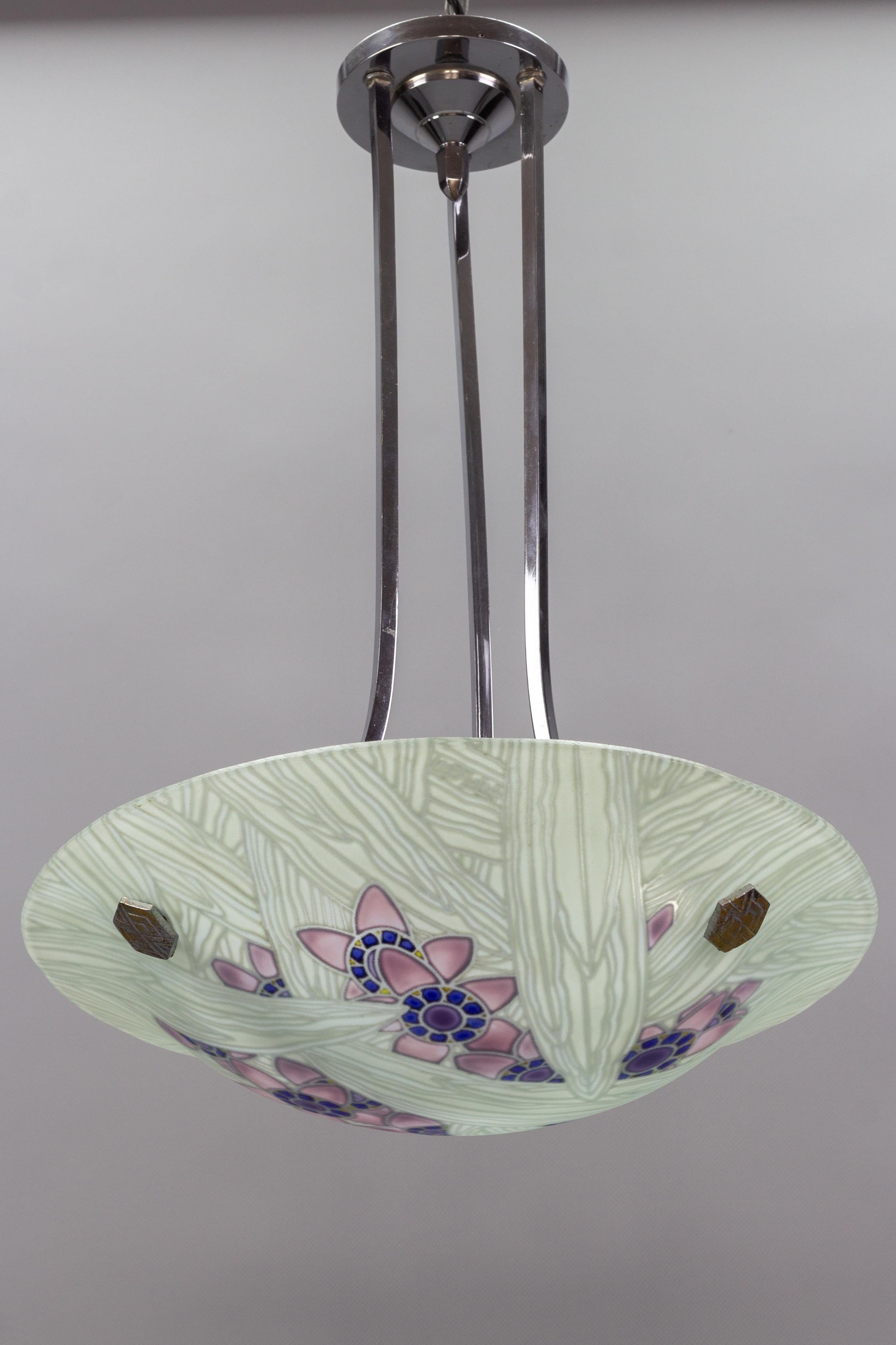 Ce magnifique bol en verre dépoli et peint à la main de la période Art déco présente d'adorables motifs floraux intérieurs et de grandes feuilles dans de doux pastels : violet, violet, bleu et blanc. L'abat-jour en verre est signé 