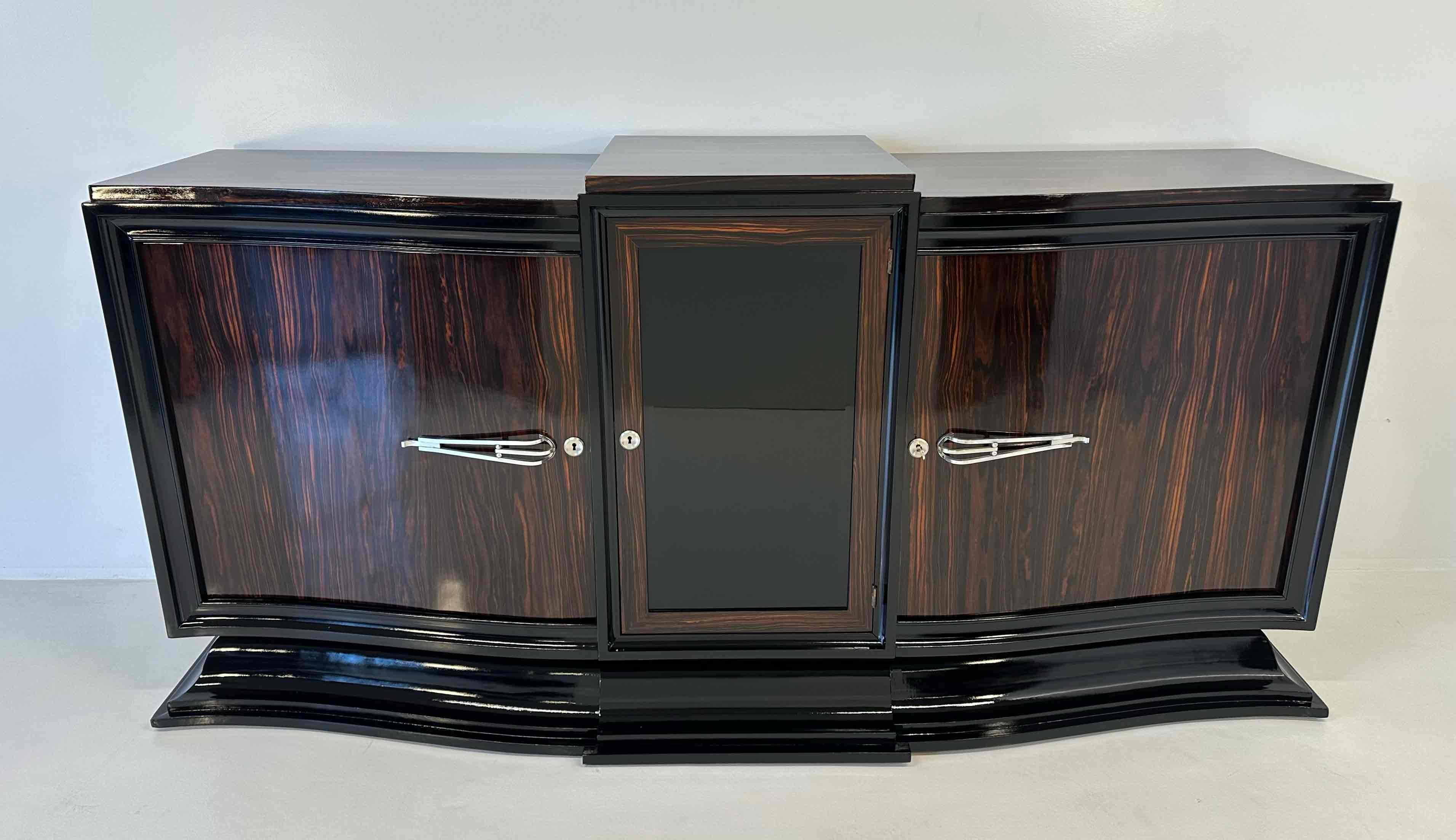 Questa splendida credenza Art Déco è stata realizzata in Francia negli anni '30 e presenta la silhouette elegantemente curvata tipica del design Art Déco francese.
Realizzato interamente in legno di Macassar con profili laccati in nero, vanta un
