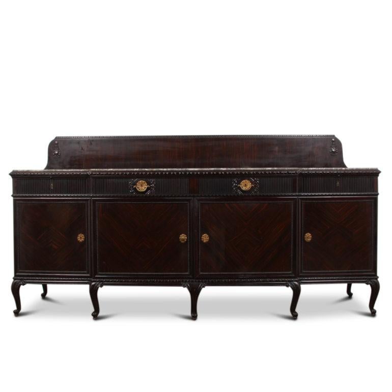 A fabulous-quality French Art Deco breakfront buffet of grand proportions, with four lower cabinets below four drawers. The exterior surfaces feature book-matched patterns of richly-grained Macassar ebony veneer; carved details, drawer fronts, legs,