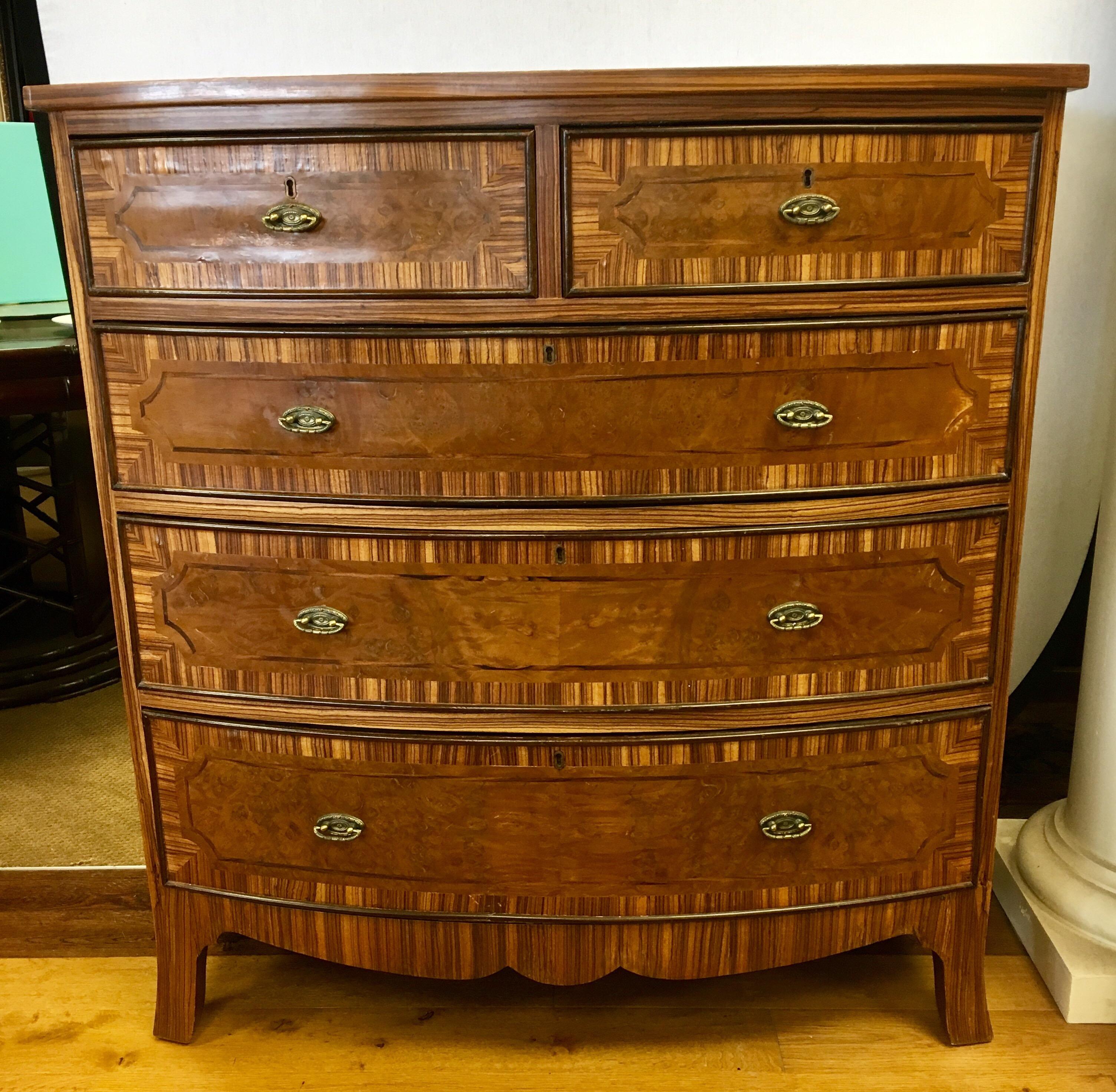 Magnificent and rare tall chest of drawers is handcrafted in a combination of two woods, Macassar ebony and burl wood. It has five drawers with original hardware and is slightly bowed in shape. The top and drawers are framed with Macassar ebony
