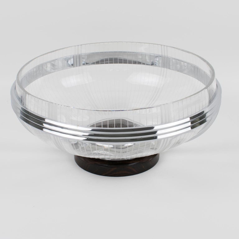 Stylish French Art Deco 1930s centerpiece or serving bowl. Rounded shape with Macassar wood base and chromed metal body. The central bowl insert is in cut crystal with beveling and etching. No visible maker's mark.
Measurements: 10.82 in. diameter