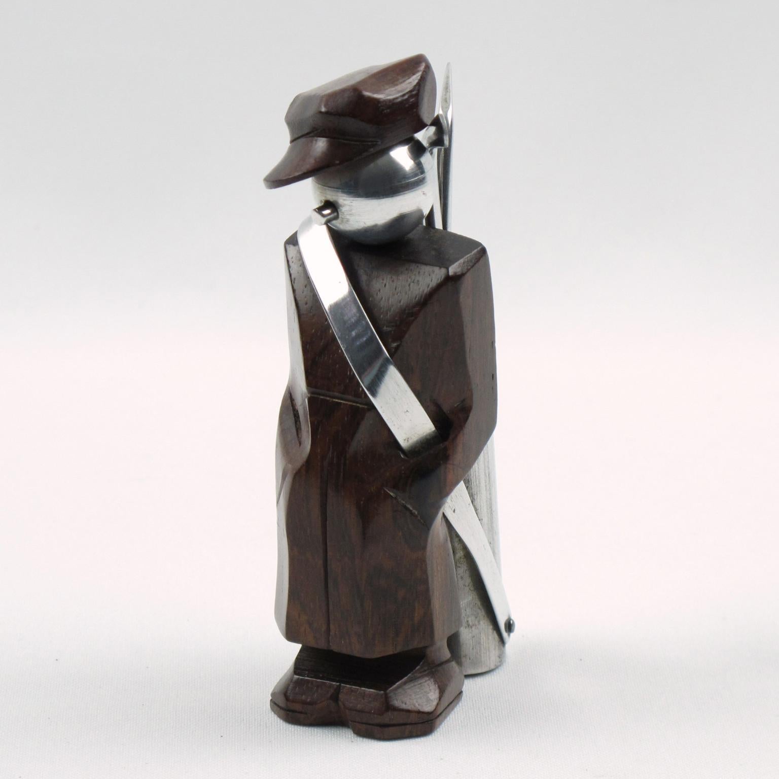 Un joli set de cocktail Art déco français en bois et aluminium. Le pic à cocktail comporte une figurine de caddie de golf en bois de Macassar sculptée à la main, avec un capuchon sculpté et une tête métallique en aluminium moulé. Le porte-club