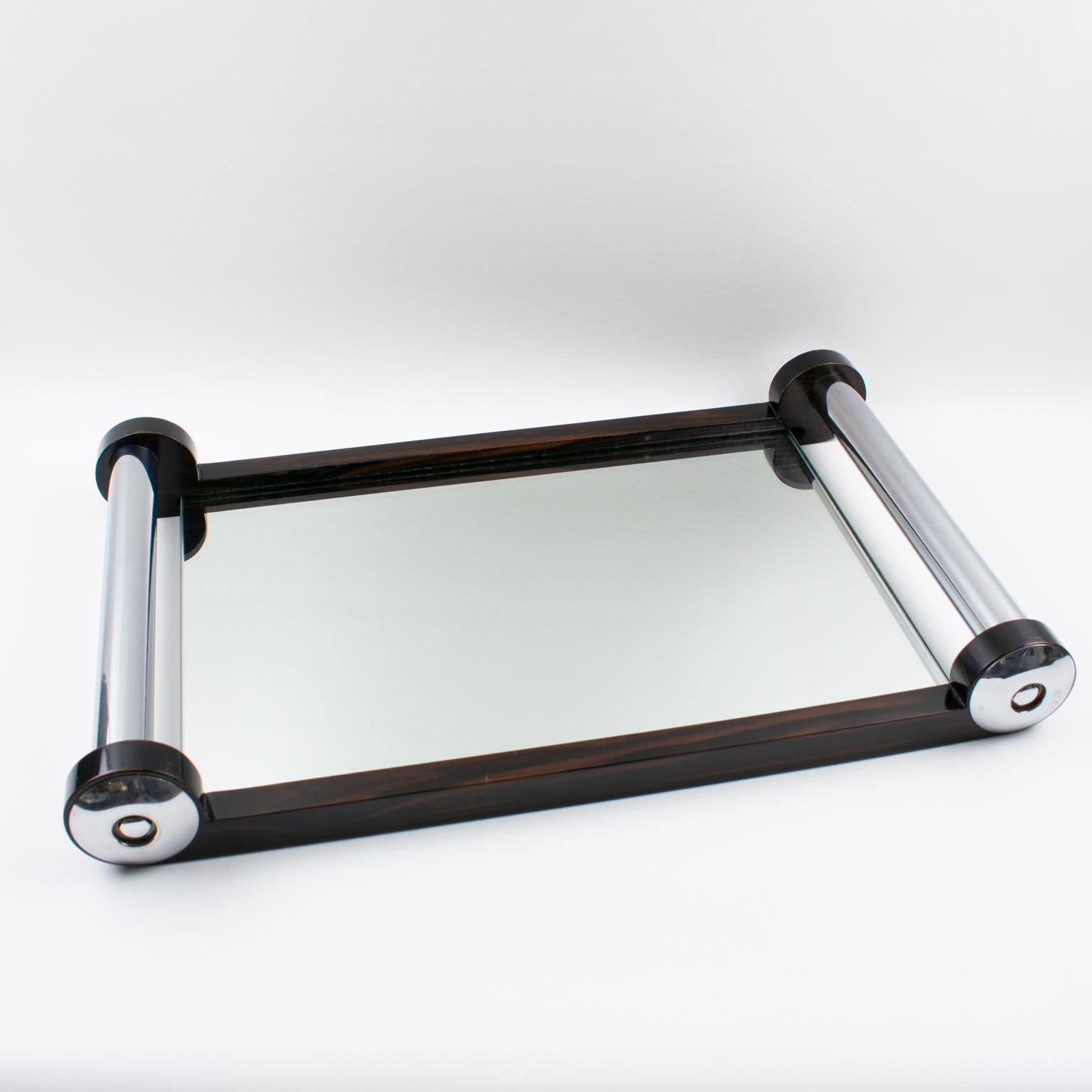 Large elegant French Art Deco barware serving tray. Chromed metal and Macassar wood rectangular gallery and extra thick handles. Insert base is in mirrored glass. Modernist design and geometric streamlined shape offer all the elegance one could