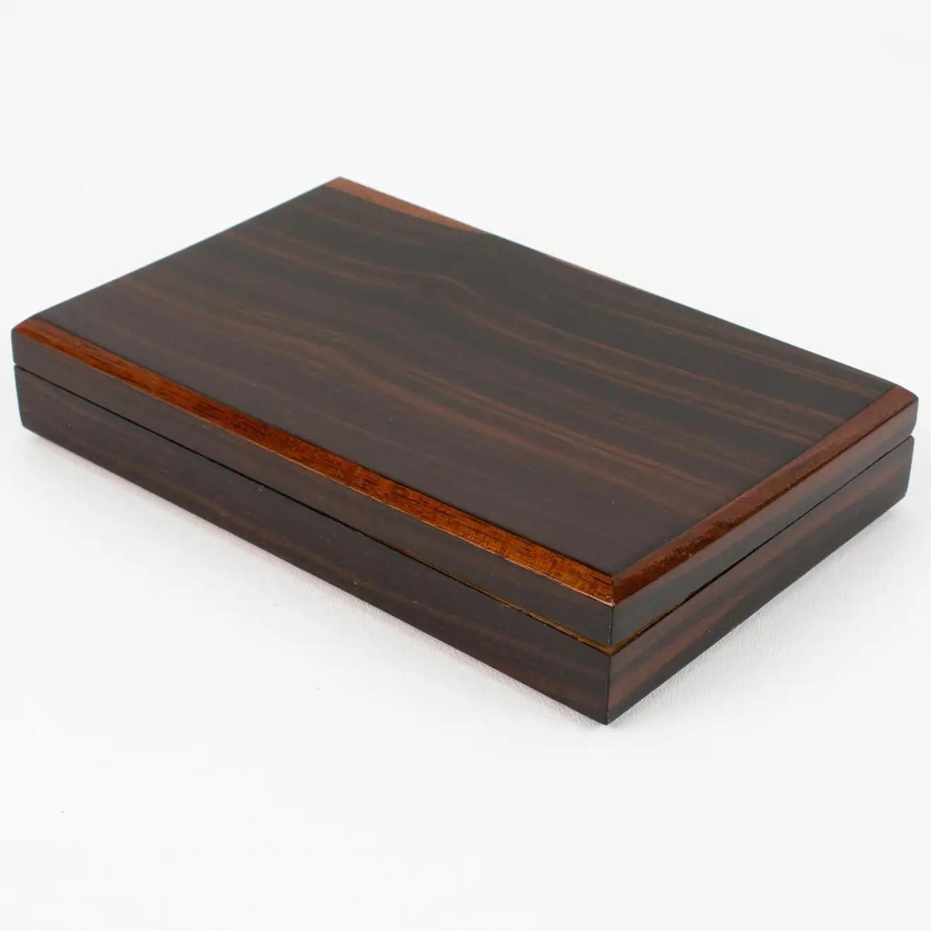 This elegant French Art Deco modernist decorative lidded box boasts a minimalist yet refined and sophisticated shape with varnish Macassar wood ornate with tropical wooden edging trims. The interior is lined with tropical wood. There is no visible
