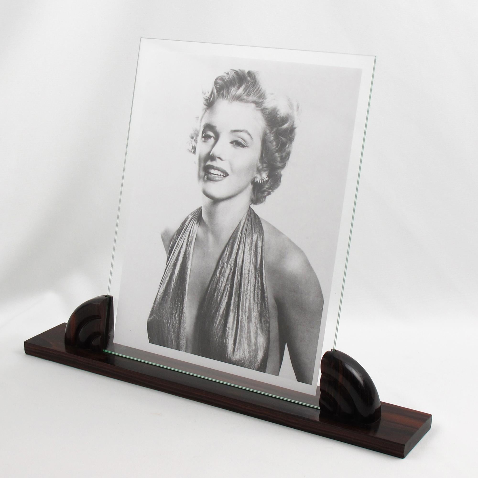 This stunning French Art Deco picture frame features a thick hand-rubbed Macassar wood plinth, complemented by the same carved wood insert holders. The photo frame is complete with two glass sheets to enclose the photography. There is no visible