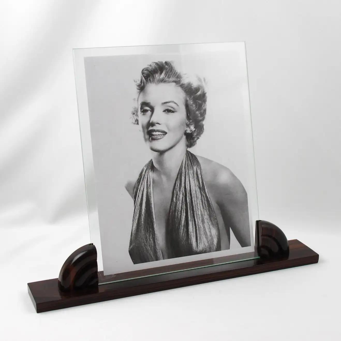 This stunning French Art Deco picture photo frame features a thick hand-rubbed Macassar wood plinth complimented with the same carved wood insert holders. The photo frame is complete with two glass sheets to enclose the photography. There is no