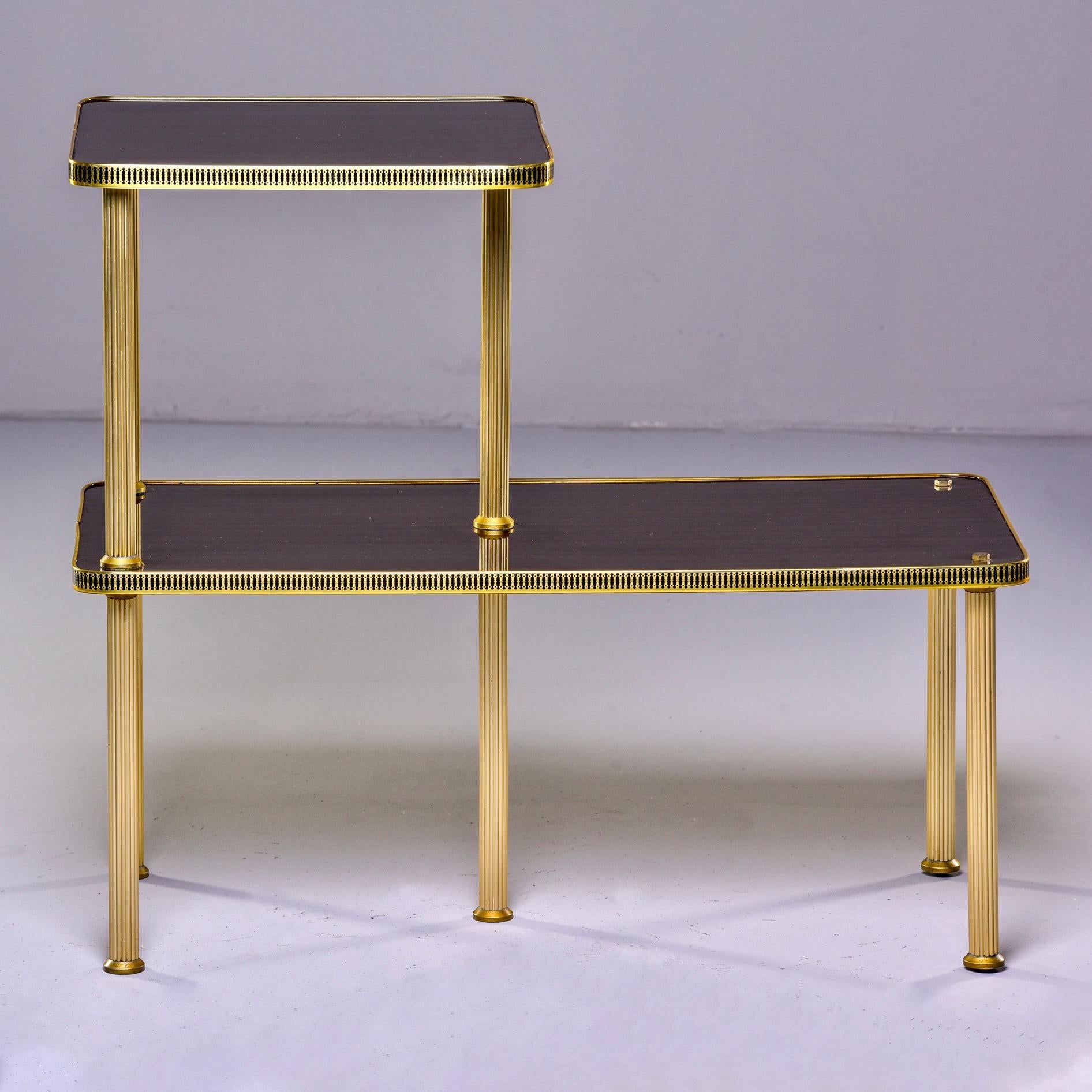 French Guéridon two tier side table, circa 1940s. Mahogany veneer with brass gallery around the edges and ridged brass legs. Unknown maker. Lower tier has fine surface scratches, see detail photos.