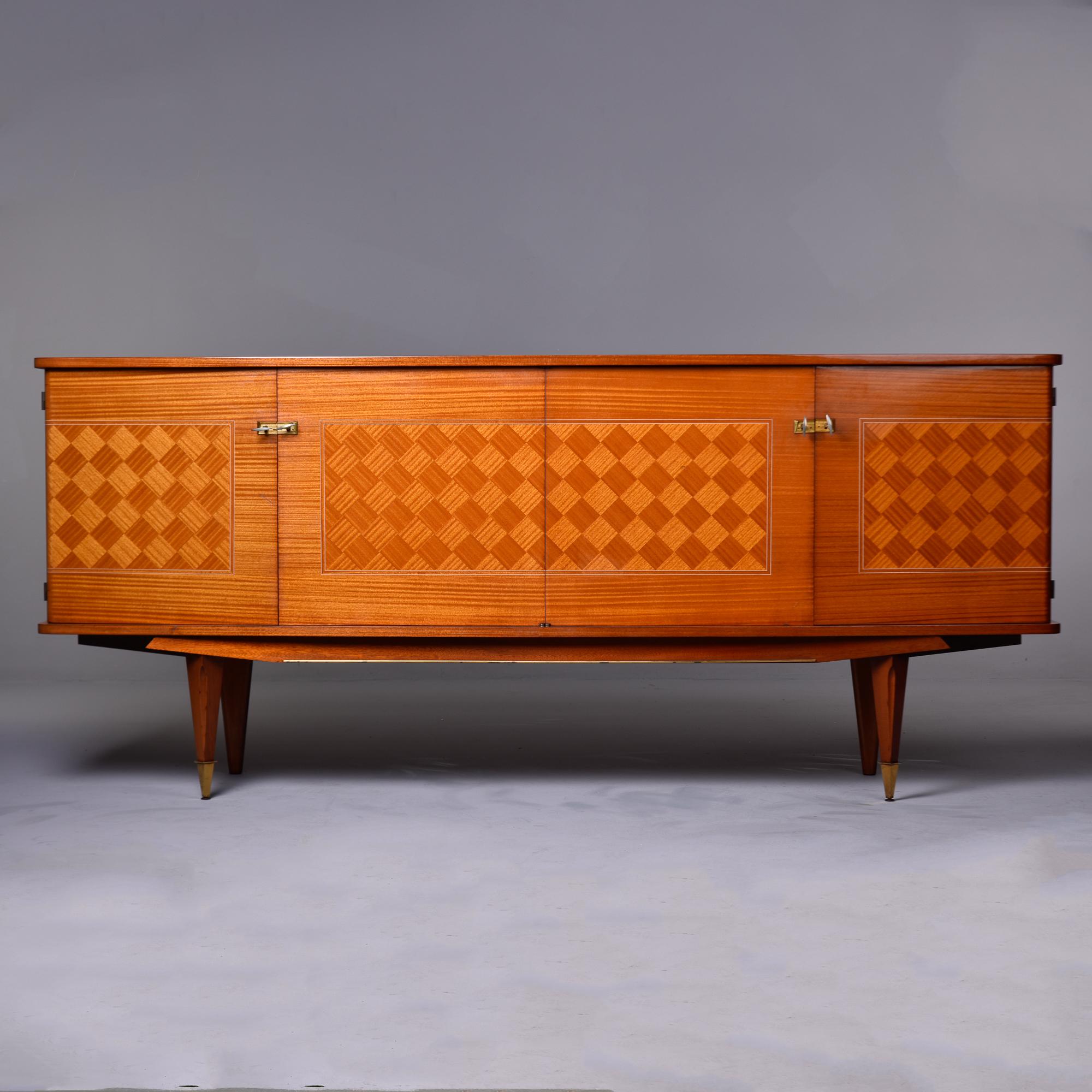 Found in France, this circa 1940s cabinet works as a buffet, credenza or sideboard. Good size at just over 88” wide. Light colored mahogany has intricate checkerboard parquetry on the door fronts and side panels. Lots of storage - middle compartment