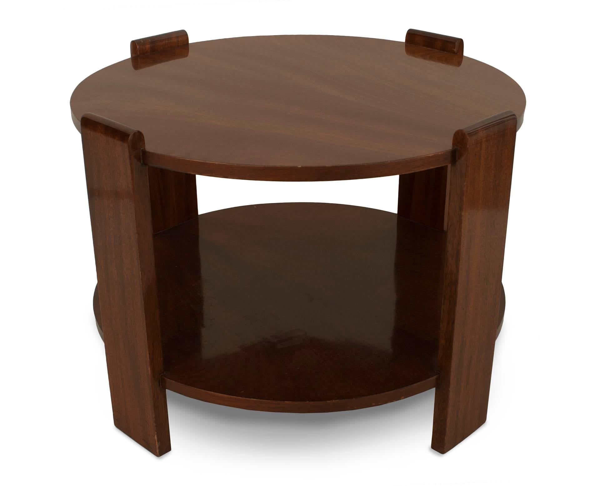 French Art Deco round mahogany coffee table with a lower shelf supported by four side supports with rounded tops.
