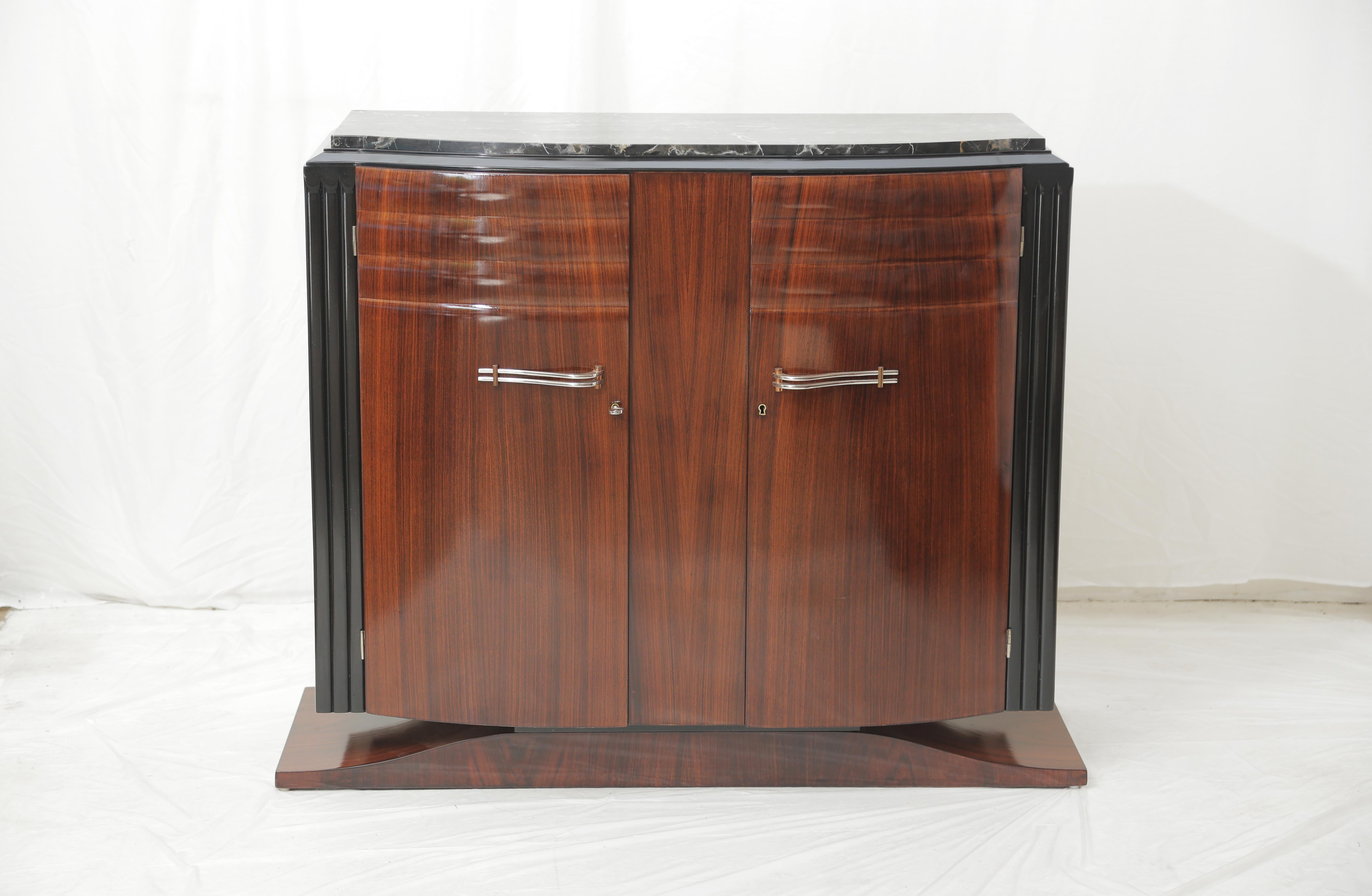Adorable French late Art Deco (circa 1940) small cabinet in mahogany.
Two curved front doors with two long shelves on the inside, the cabinet stands on an elegant curved shape base and has a very elegant black and gold marble top.
The piece would