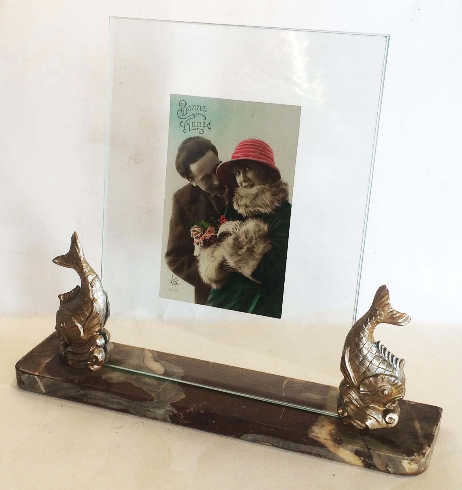 Art Deco, Pisces or double fish, photo frame on polychrome, Belgium marble base, rounded front corners. The marble is mainly plum color, with white, beige, clear and grey veins. The pair of fish supporting the 2 layers of glass that holds the photo,