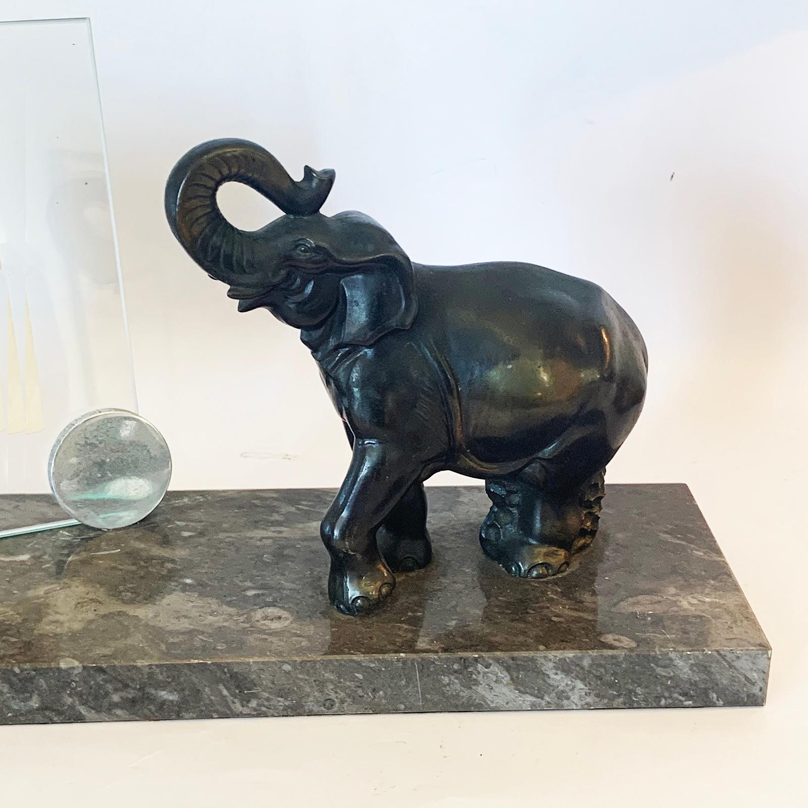 An Art Deco photo frame elephant on marble. The elephant is standing on green fossilized marble, and the base still has the original paper protection layer to base to assist non scratching to French polished surfaces, etc.. The glass is supported by