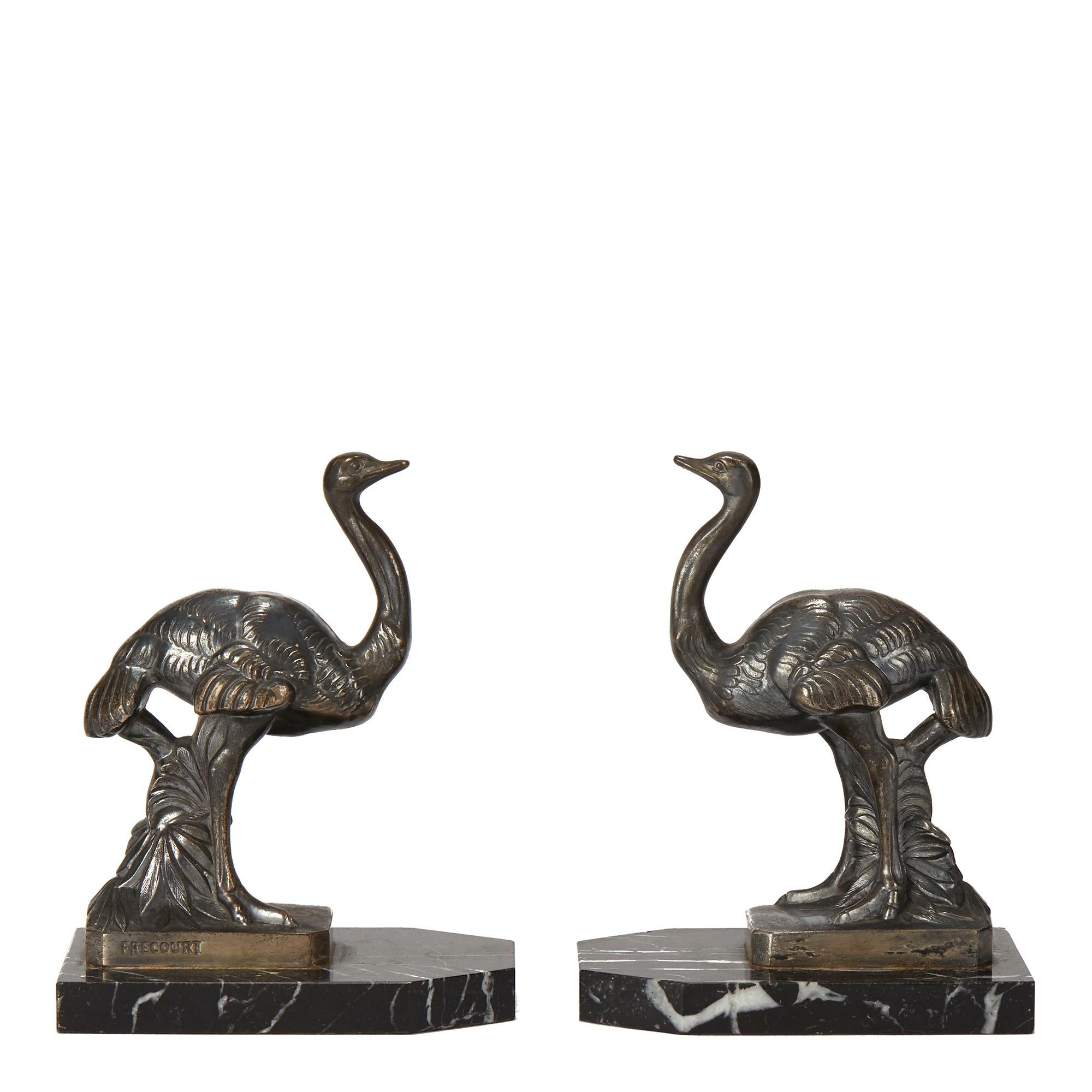 A stylish pair French Art Deco ostrich bookends by Maurice Frécourt (b.1890). The bookends mounted on veined shaped black marble bases each is mounted with a standing ostrich in a silvered metal finish. The ostrich is signed FRECOURT to the lower