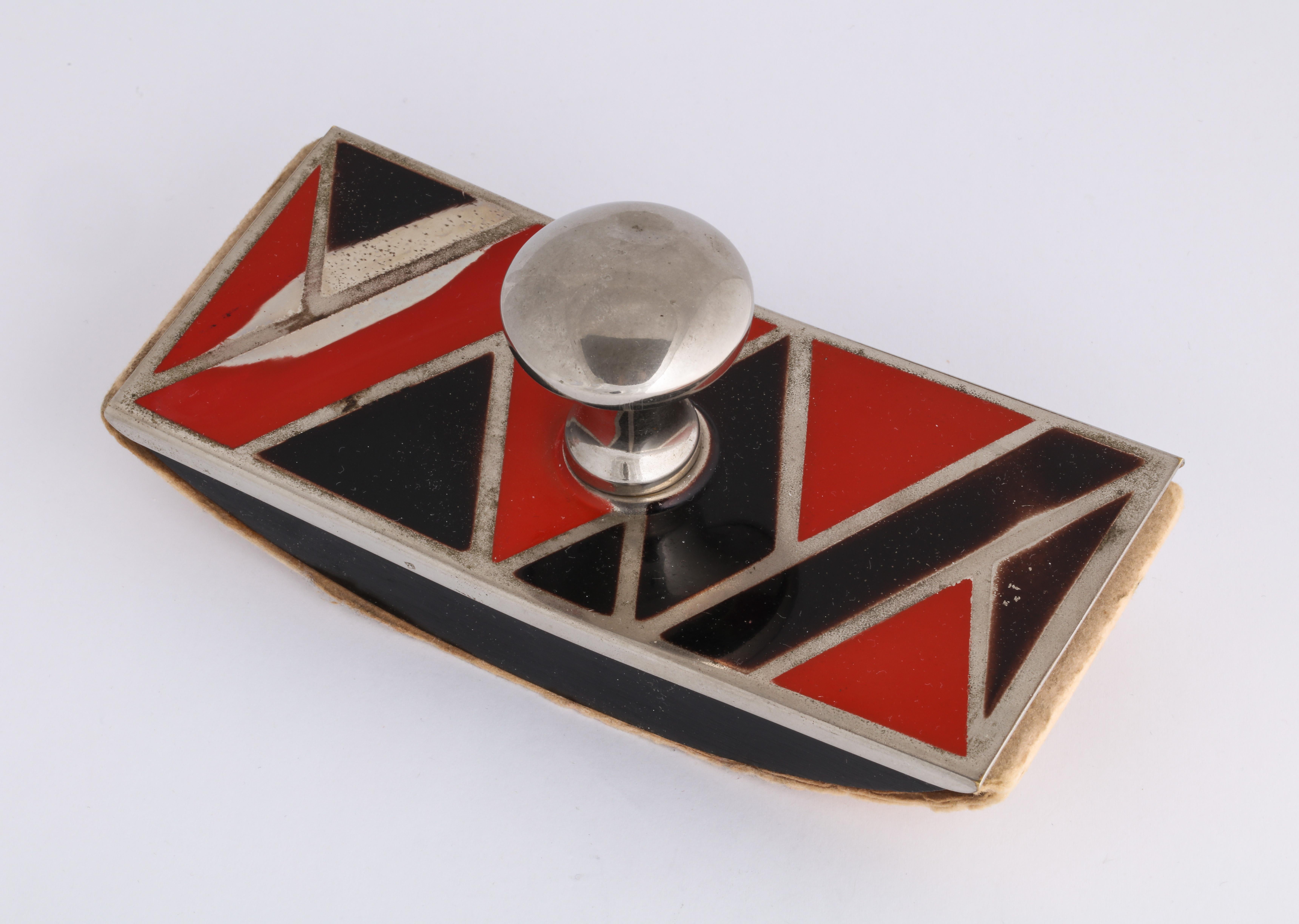 Metal with enamel in geometric design. Triangles and rectangles in black and red enamel with silver metal outlining.