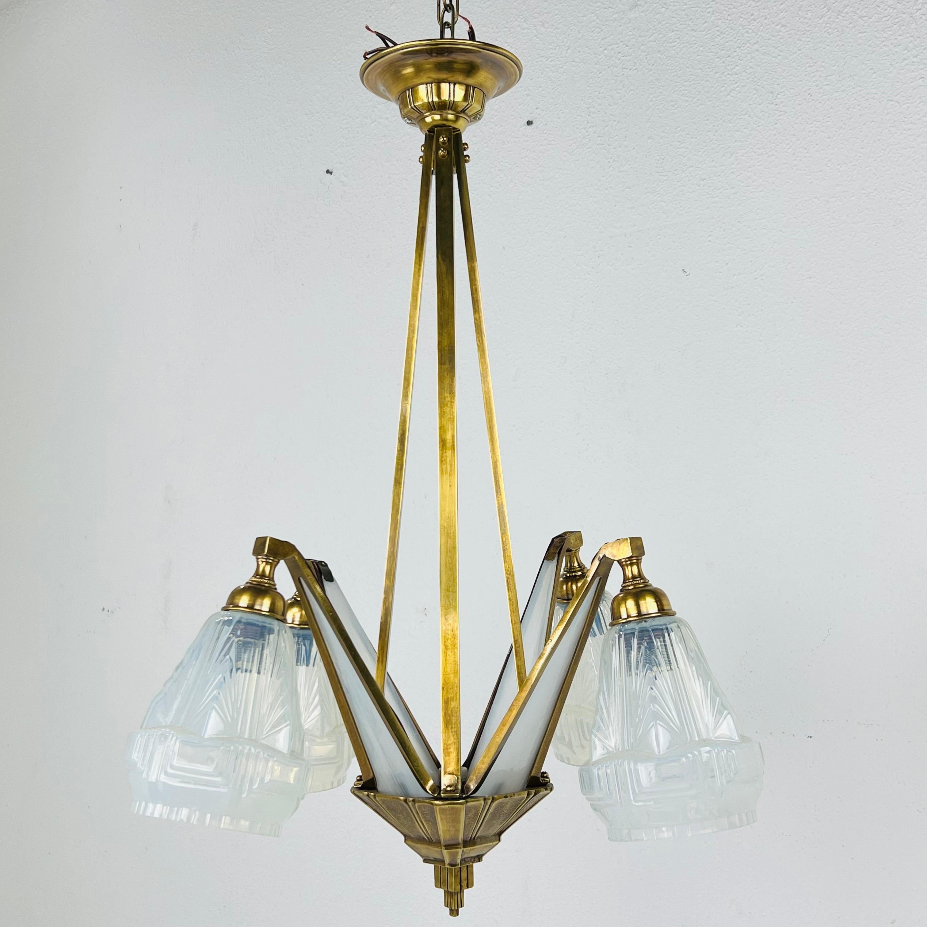 French Art Deco chandelier in style of Degues. This ceiling light is a remarkable example of the craftsmanship and style of the early 20th century. This chandelier cleverly combines metal and glass and harmoniously combines functionality and