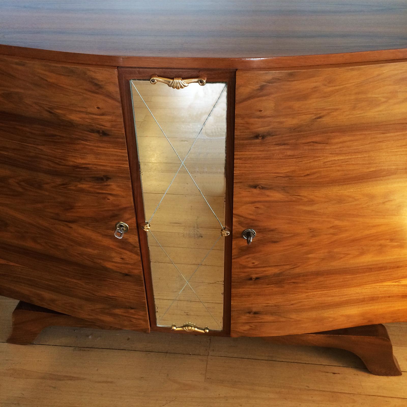 Art Deco sideboard central diamond cut mirror, and symmetrical veneered dark birch case. The mirror is mounted with ornate bronze sections top and bottom, with Bronze tabs at centre-points. The top has spectacular, rich walnut grain timber, mirror