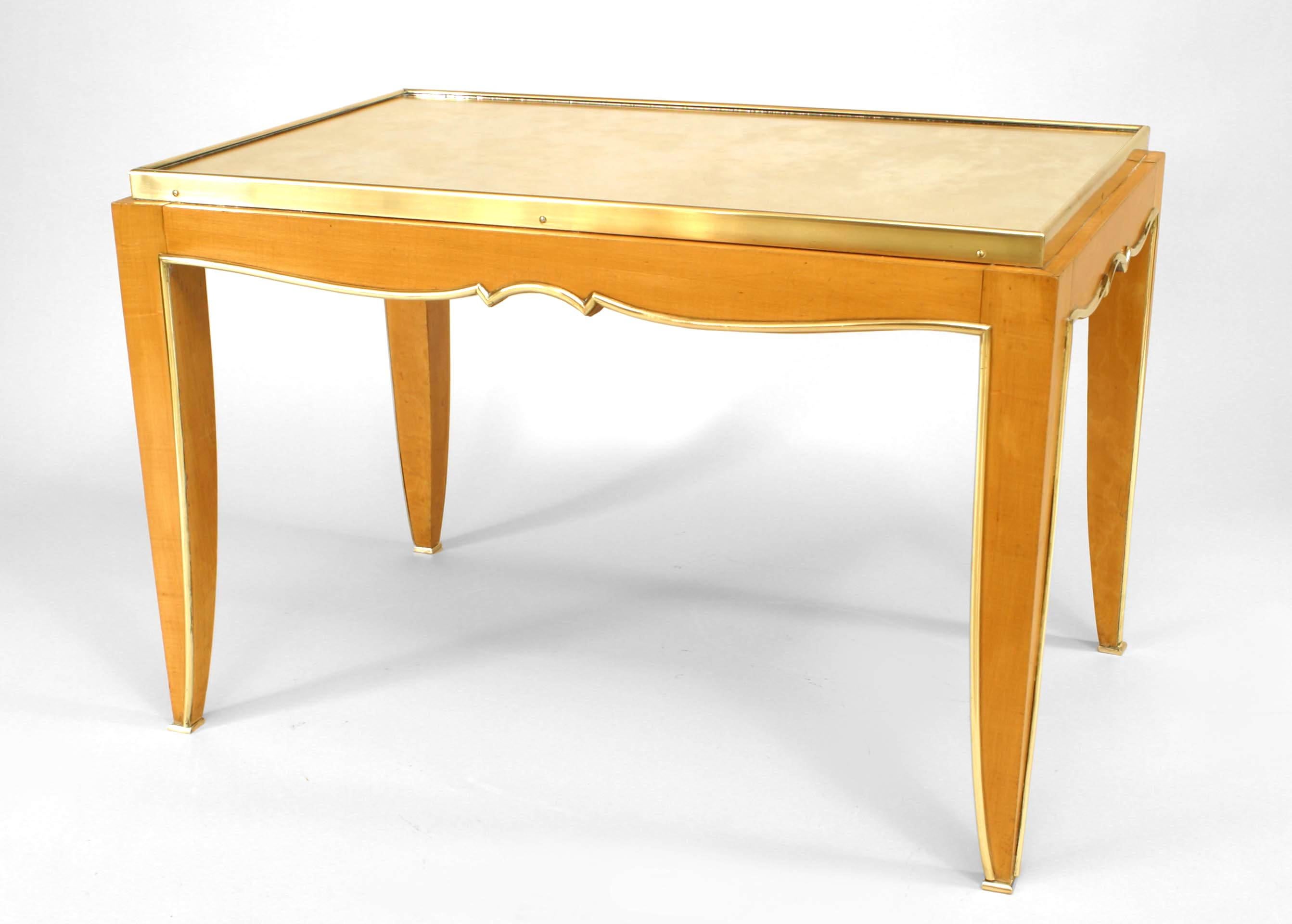 Attributed to French Art Deco designer Jules Leleu, this rectangular sycamore coffee table features an inset mirrored top over an apron and four legs decorated with bronze trim.

Jules Leleu was a French furniture designer famous for tempering