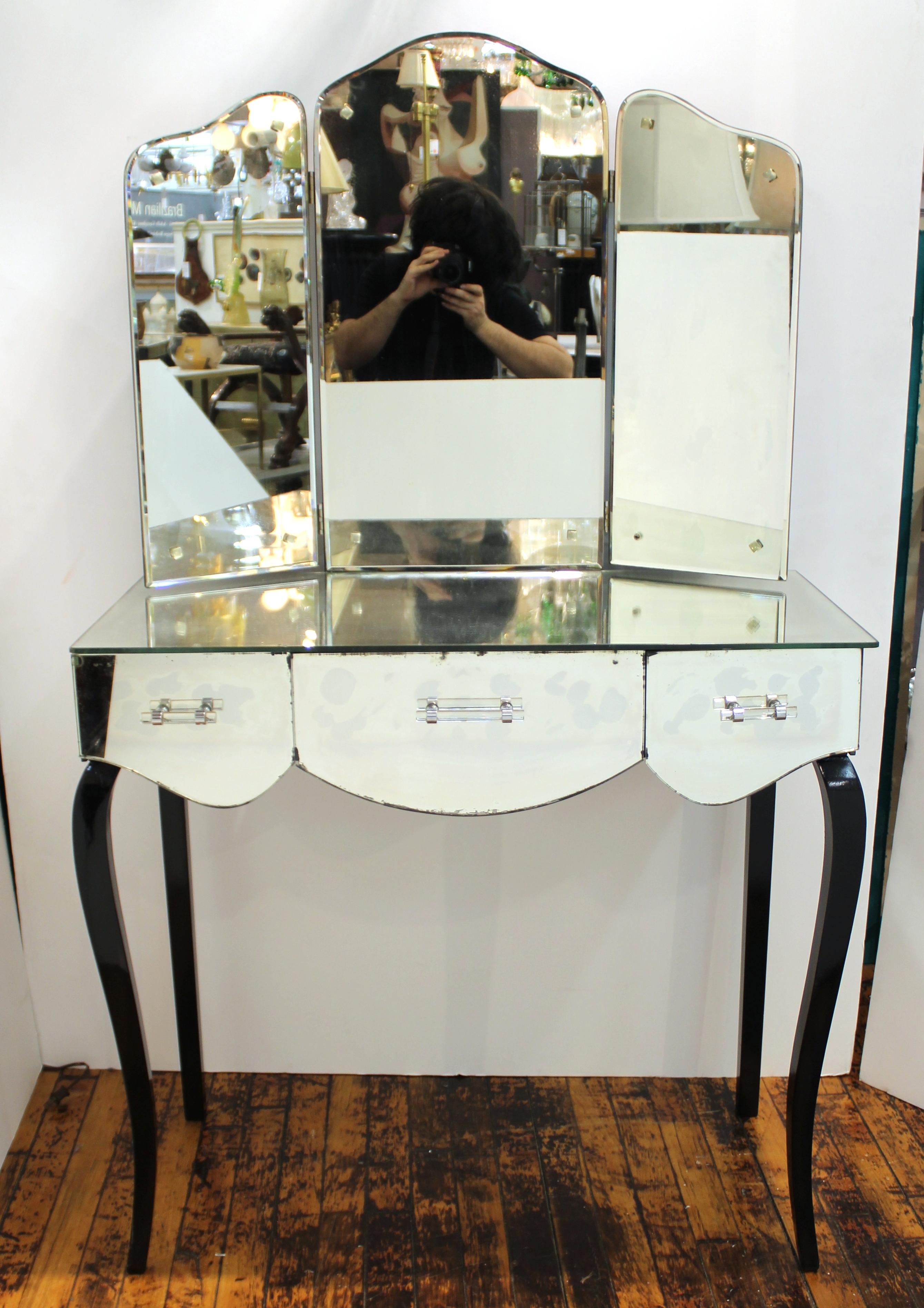 French Art Deco mirrored vanity with three drawers and a tri-fold mirror and black painted cabriole legs. The piece was made in France during the 1930s and is in great vintage condition with some age-appropriate wear.